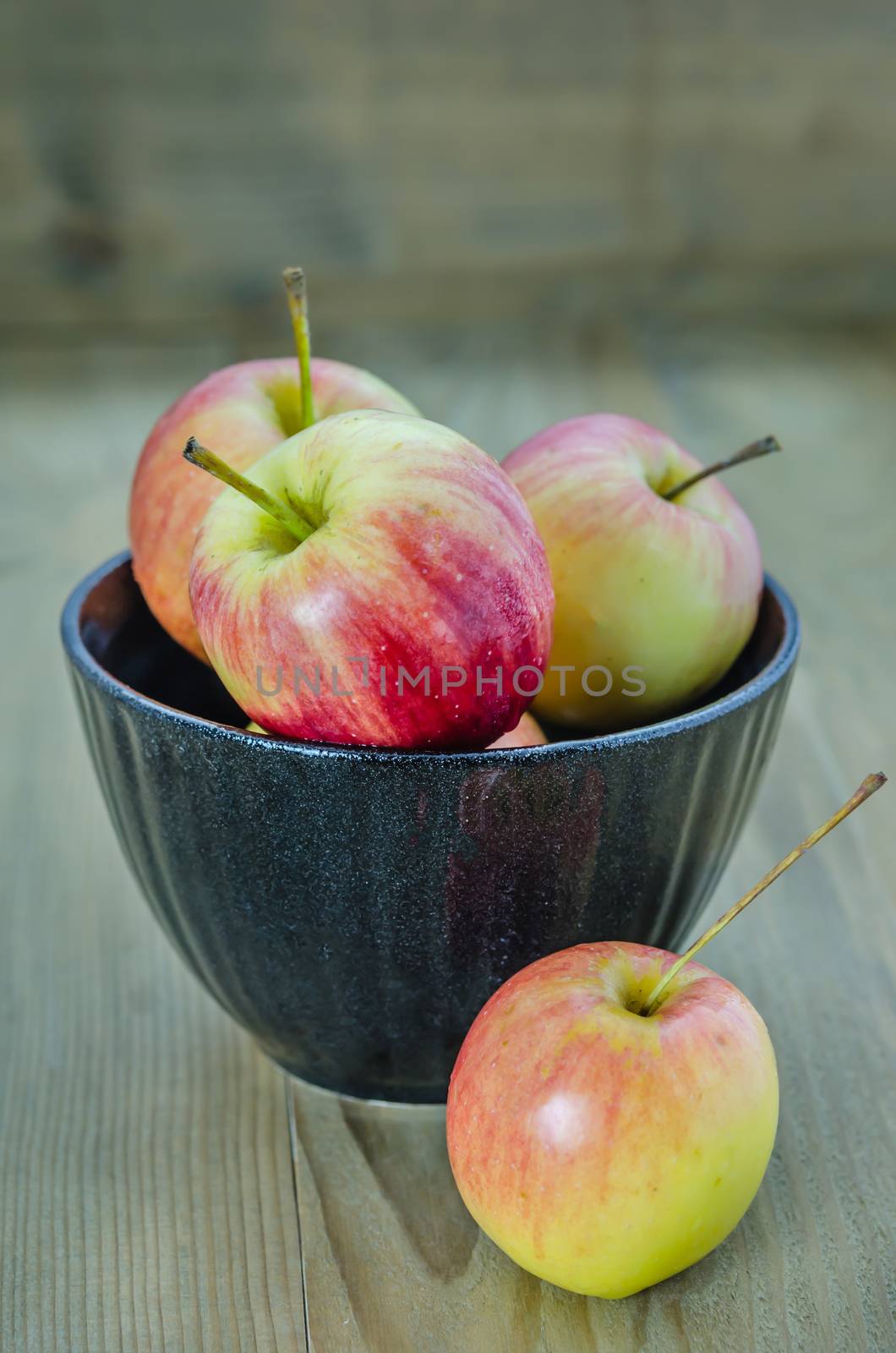 Red and yellow apple with black bowl