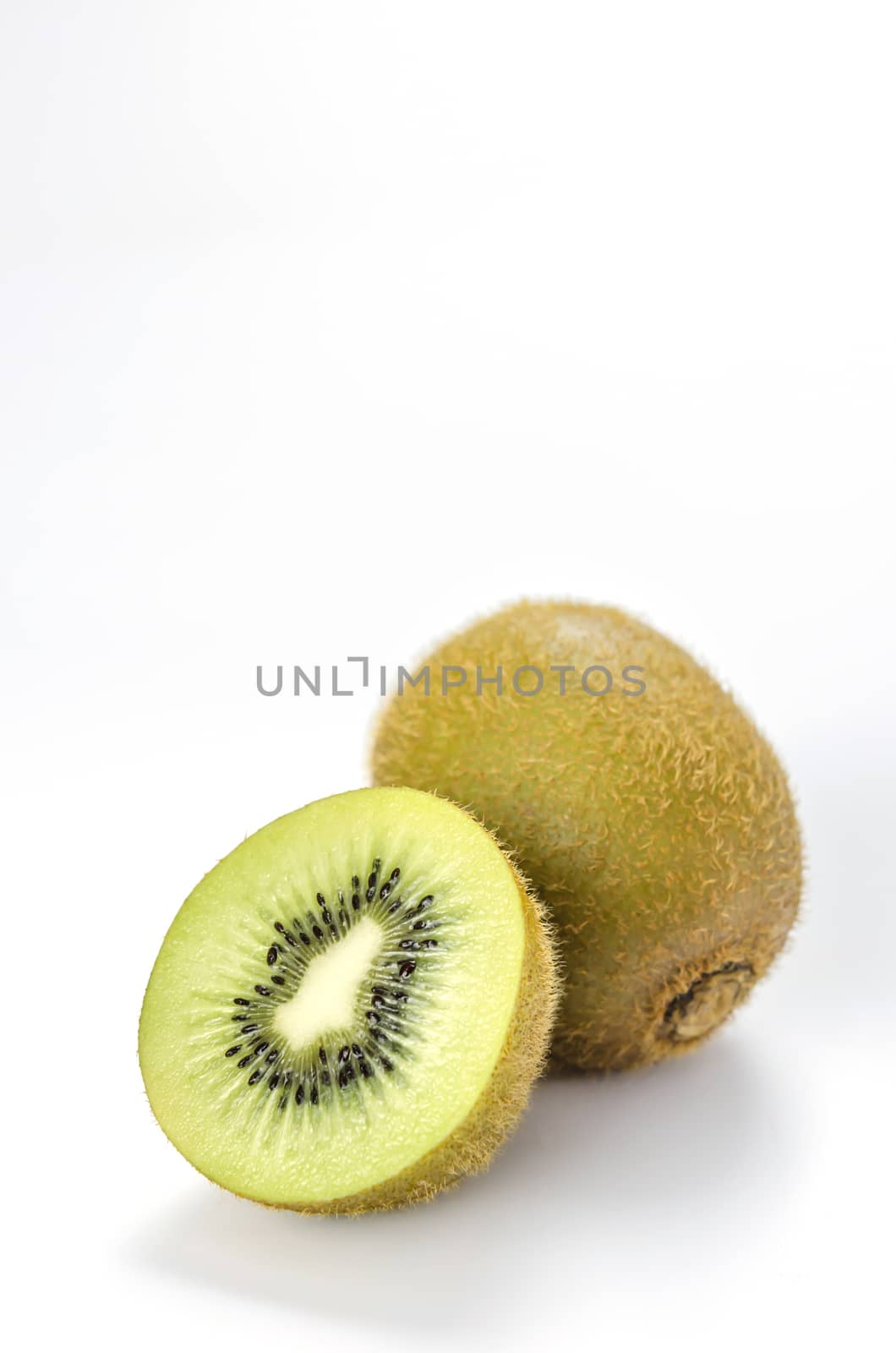 delicious whole kiwi fruit and half on white background