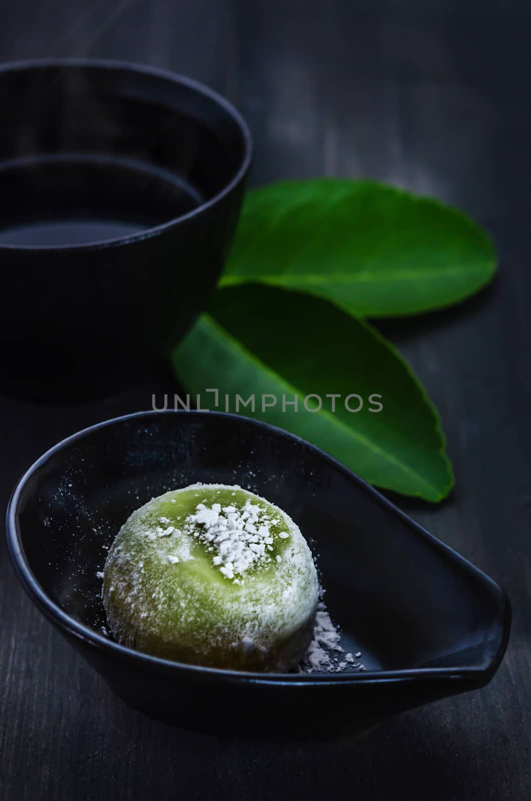Green Daifuku Mochi Japanese dessert on dish served with  hot tea , still life