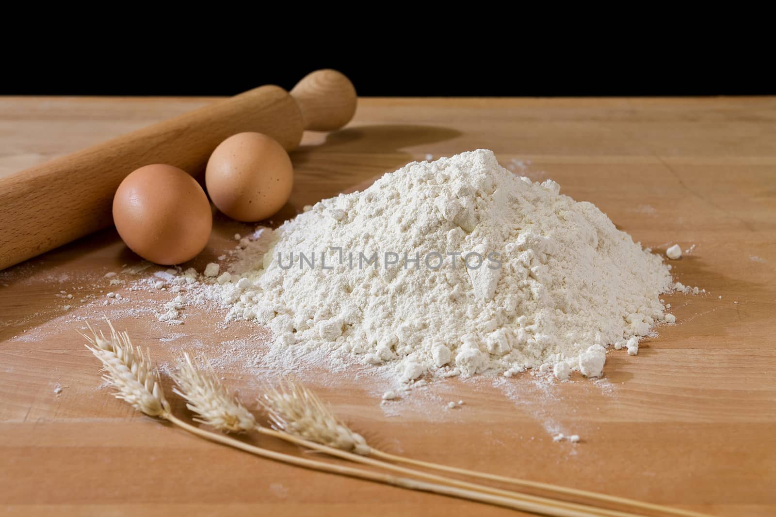 Flour and eggs on the table with rolling-pin