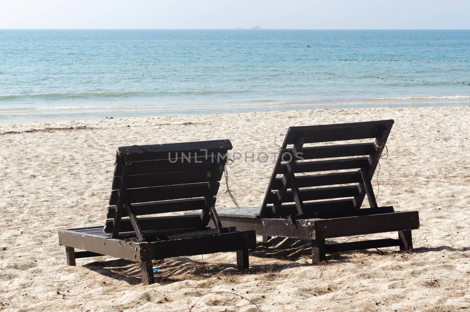 two wooden beach chairs on beautiful island in white sand plage by evolutionnow