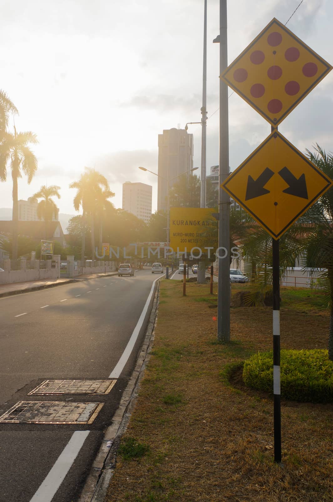 city street at dusk with light trails and traffic signm by evolutionnow