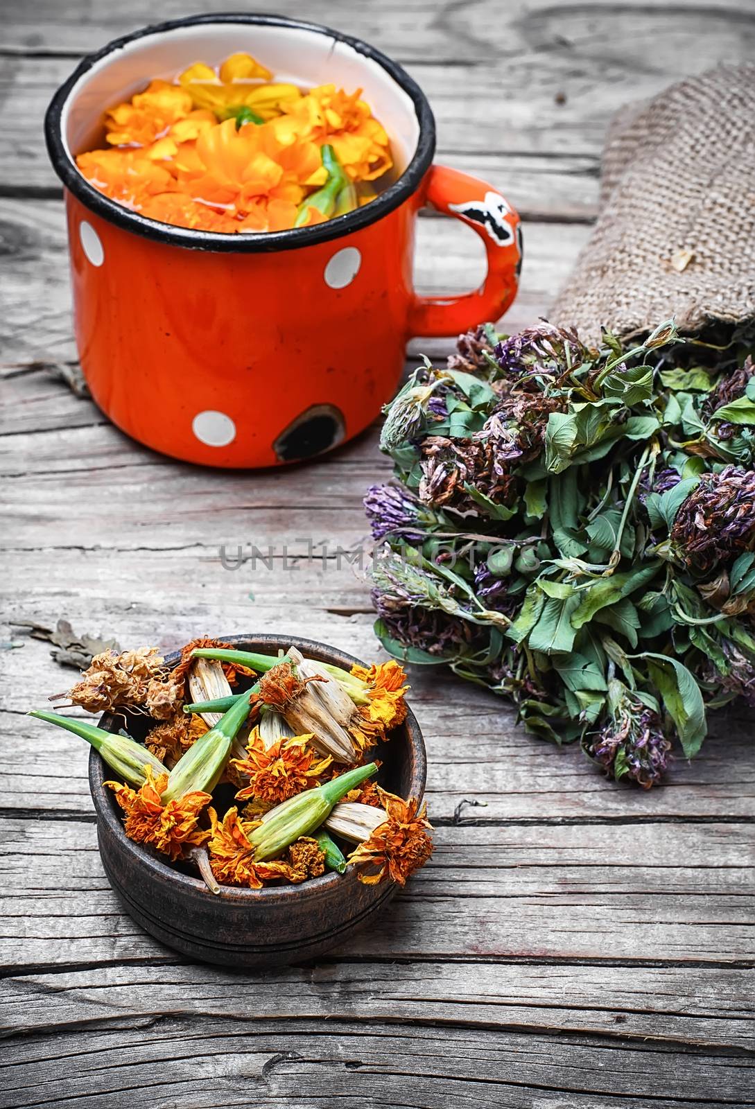 iron mug with herbal decoctions of clover and marigolds