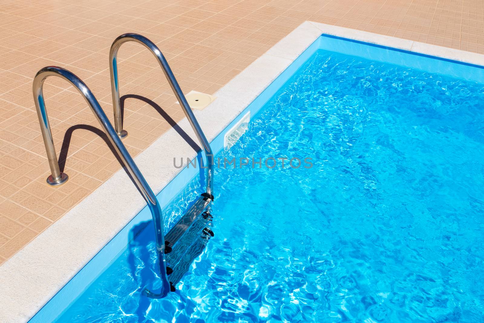 water in blue swimming pool with steps in summer season
