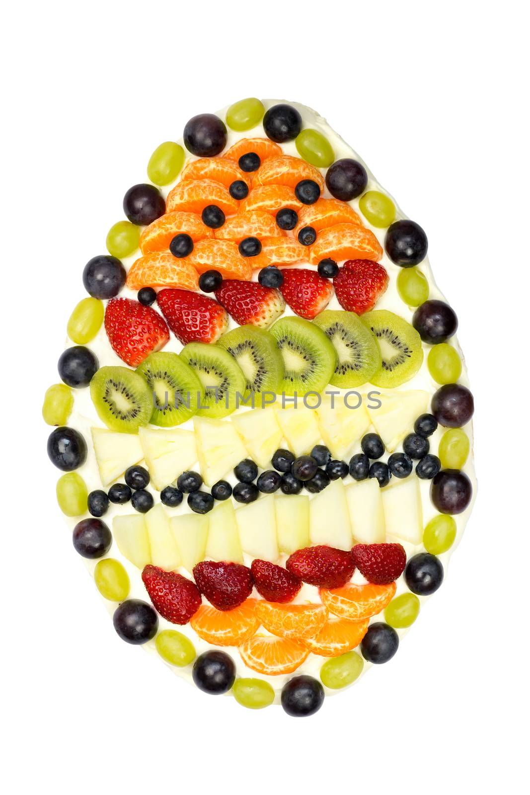 Egg shaped fruit cake covered with various fruits isolated on white background