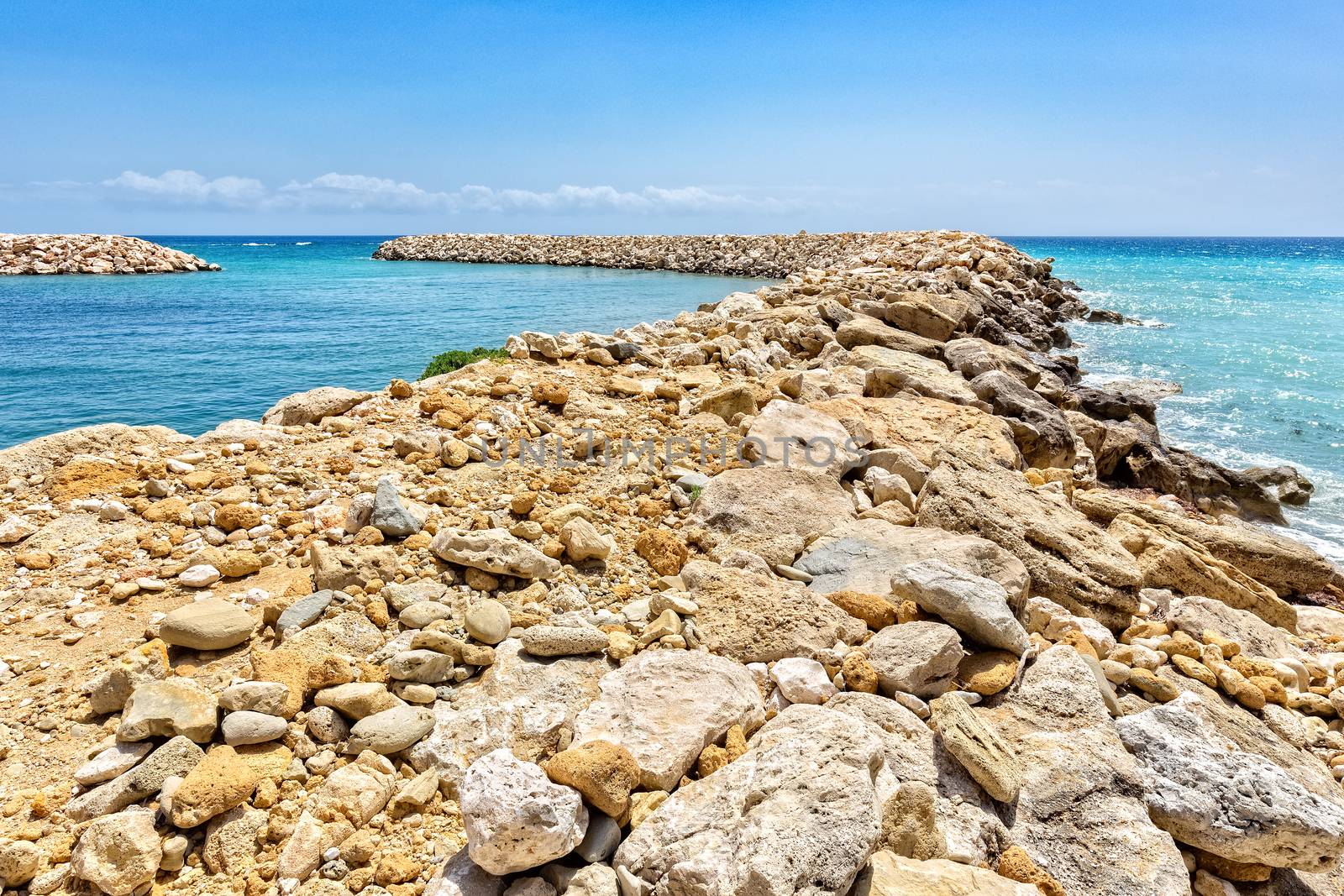 Row of rocks and stones as  weir in greek ocean