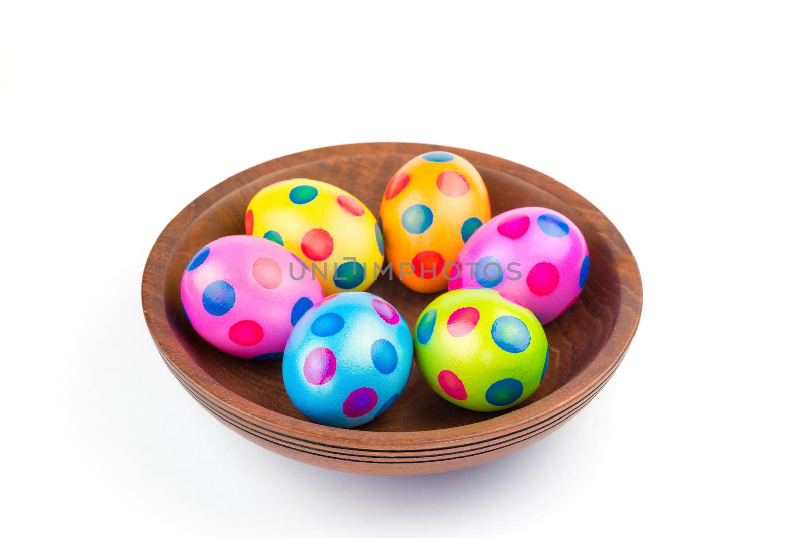 Various painted chicken easter eggs in wooden bowl on white by BenSchonewille