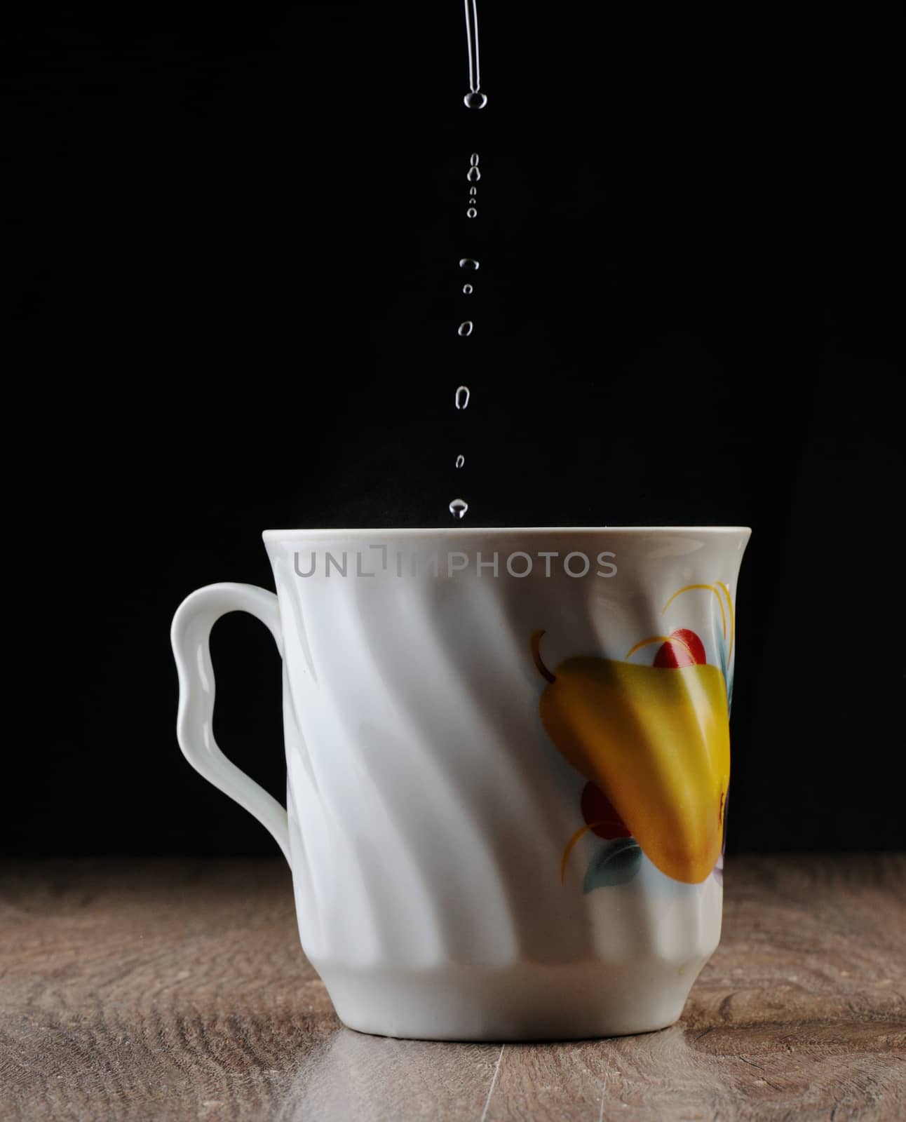 Water Drops falling in big tea cup 