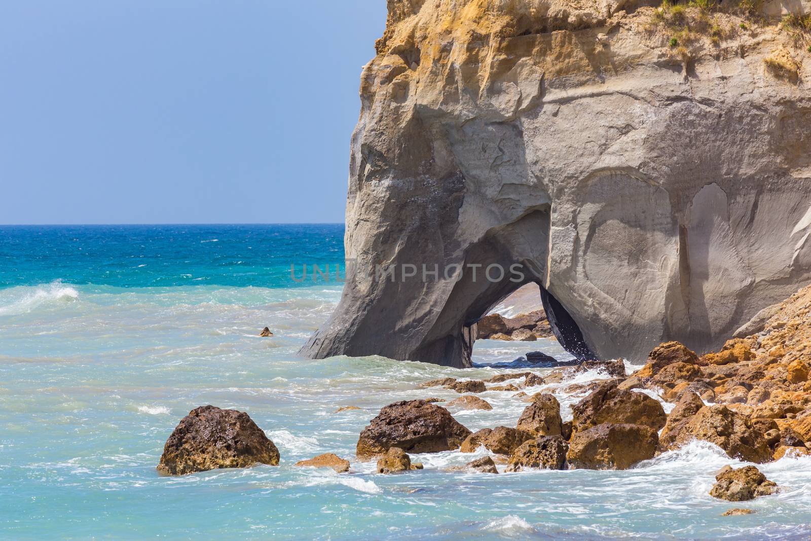 Rock with cave in sea at greek coast  by BenSchonewille