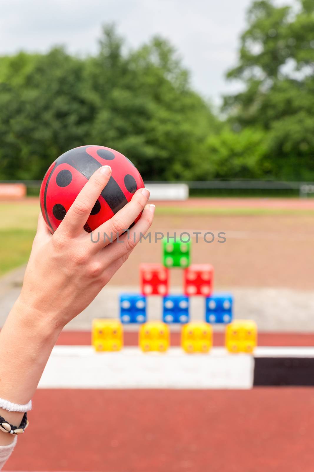 Girls arm with ball to throw at colored blocks as a game