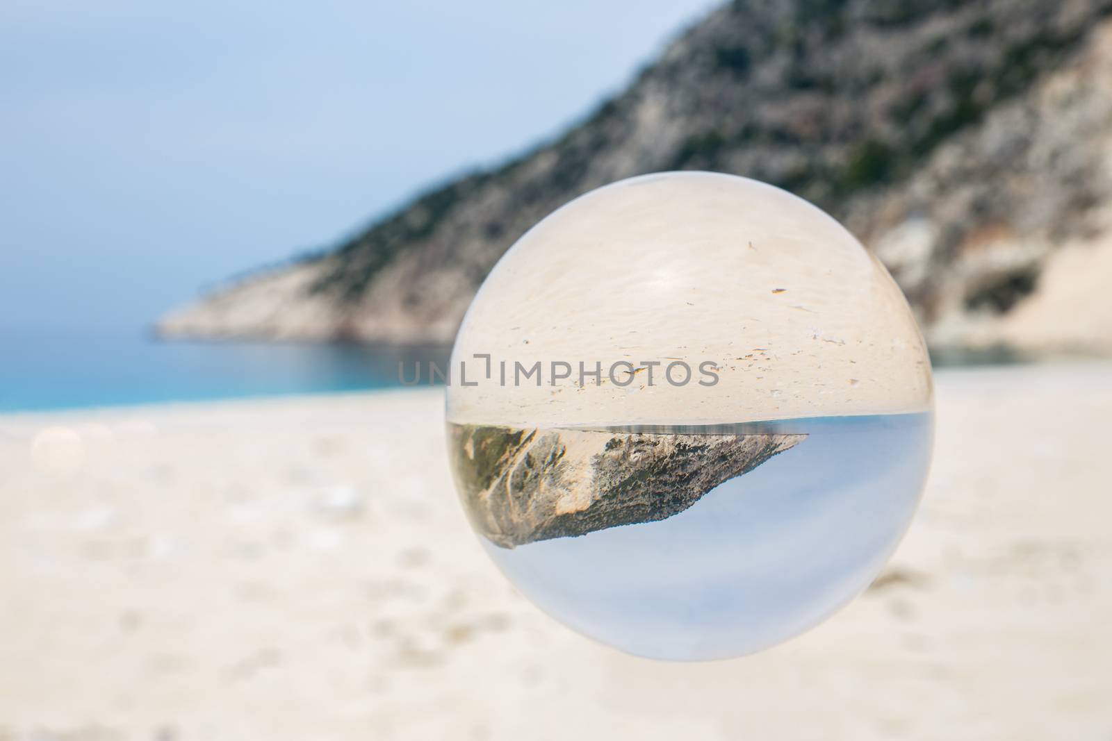 Crystal ball on sandy greek beach by BenSchonewille