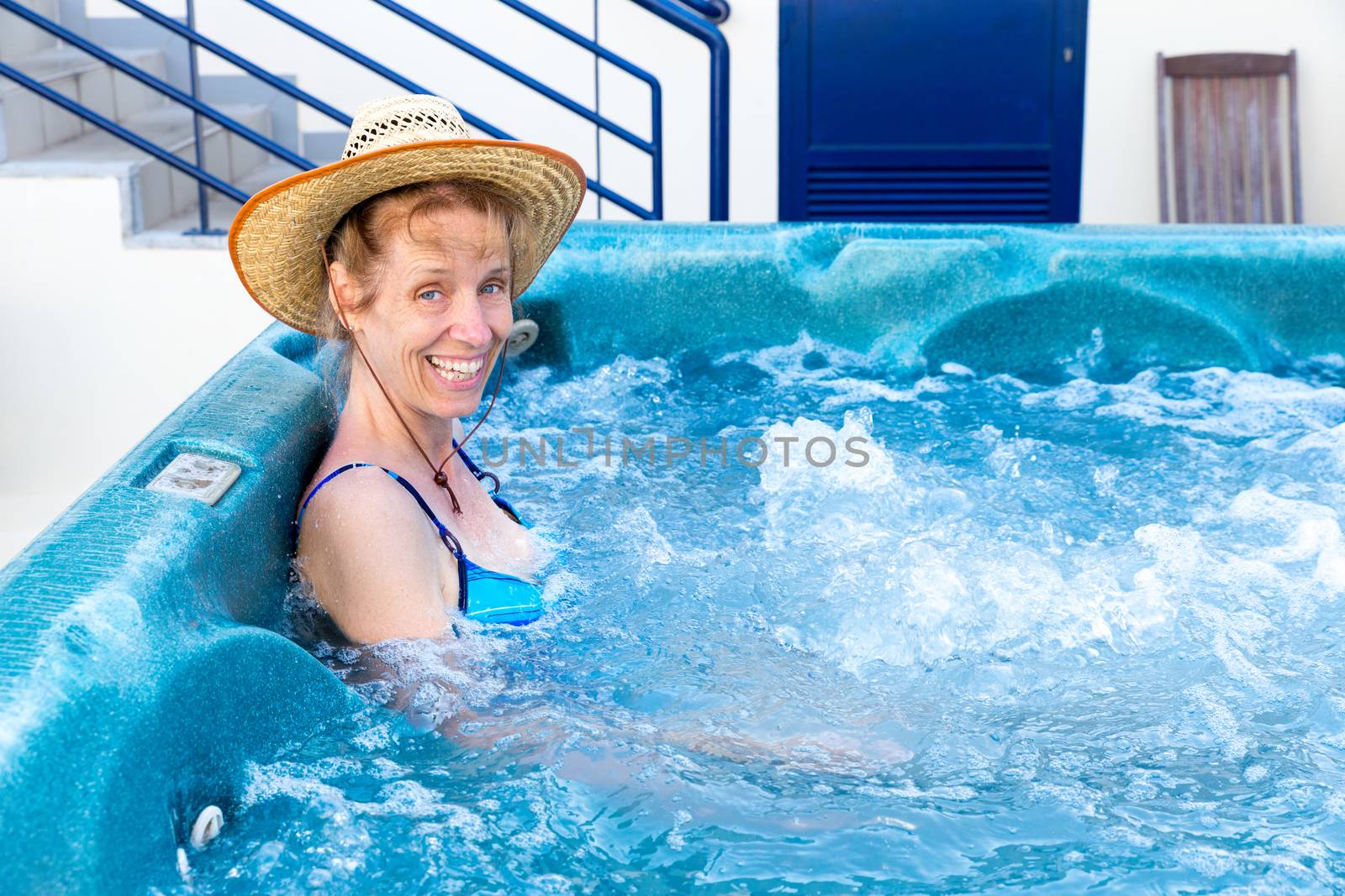 Middle aged woman bathing in hot tub by BenSchonewille