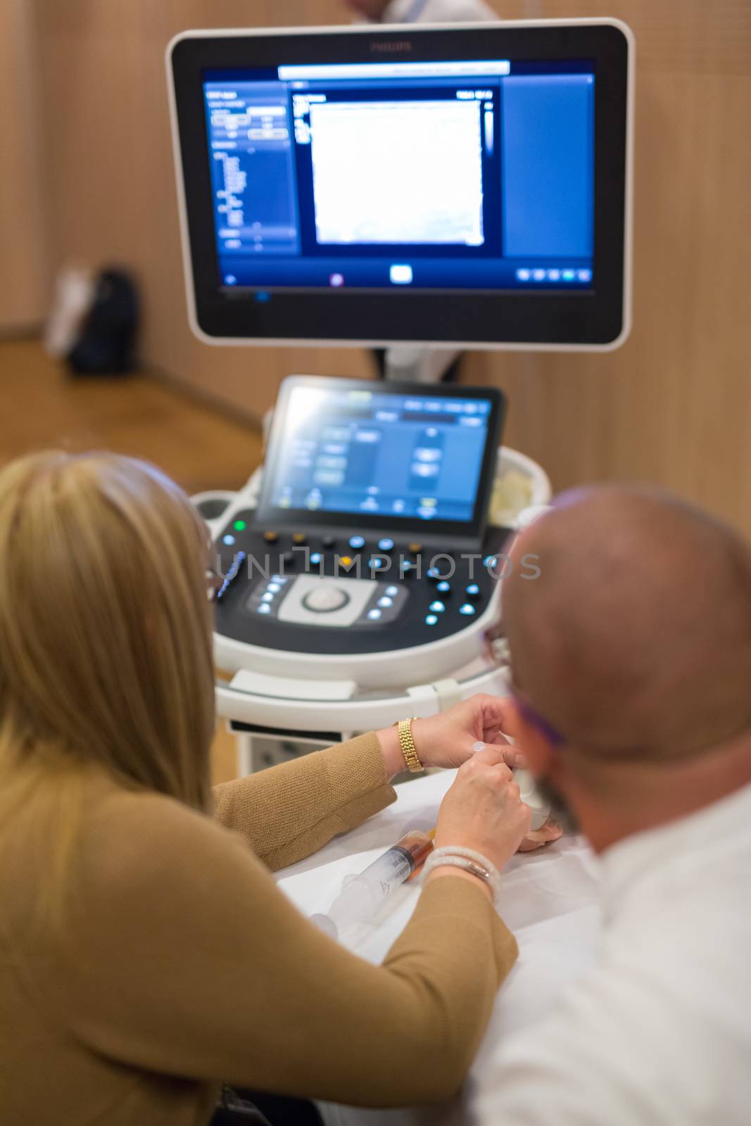 Medical doctor students learning to do medical examination of patient with ultra sound scanner machine on ultrasound techniques workshop.