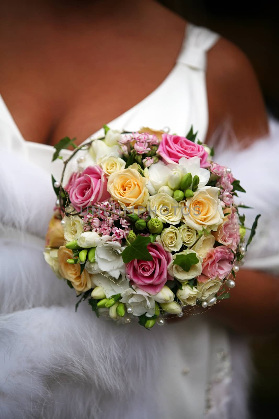 The bride holds a wedding bouquet