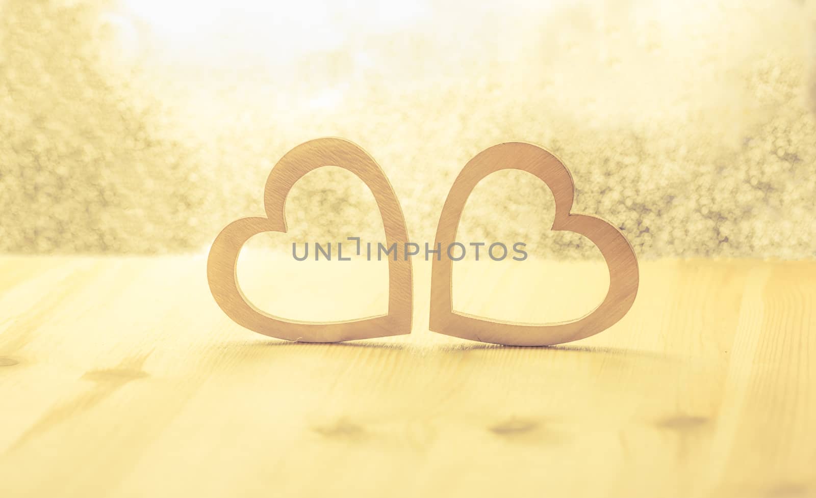 Romantic scenery with two hearts made from wood against a bright background