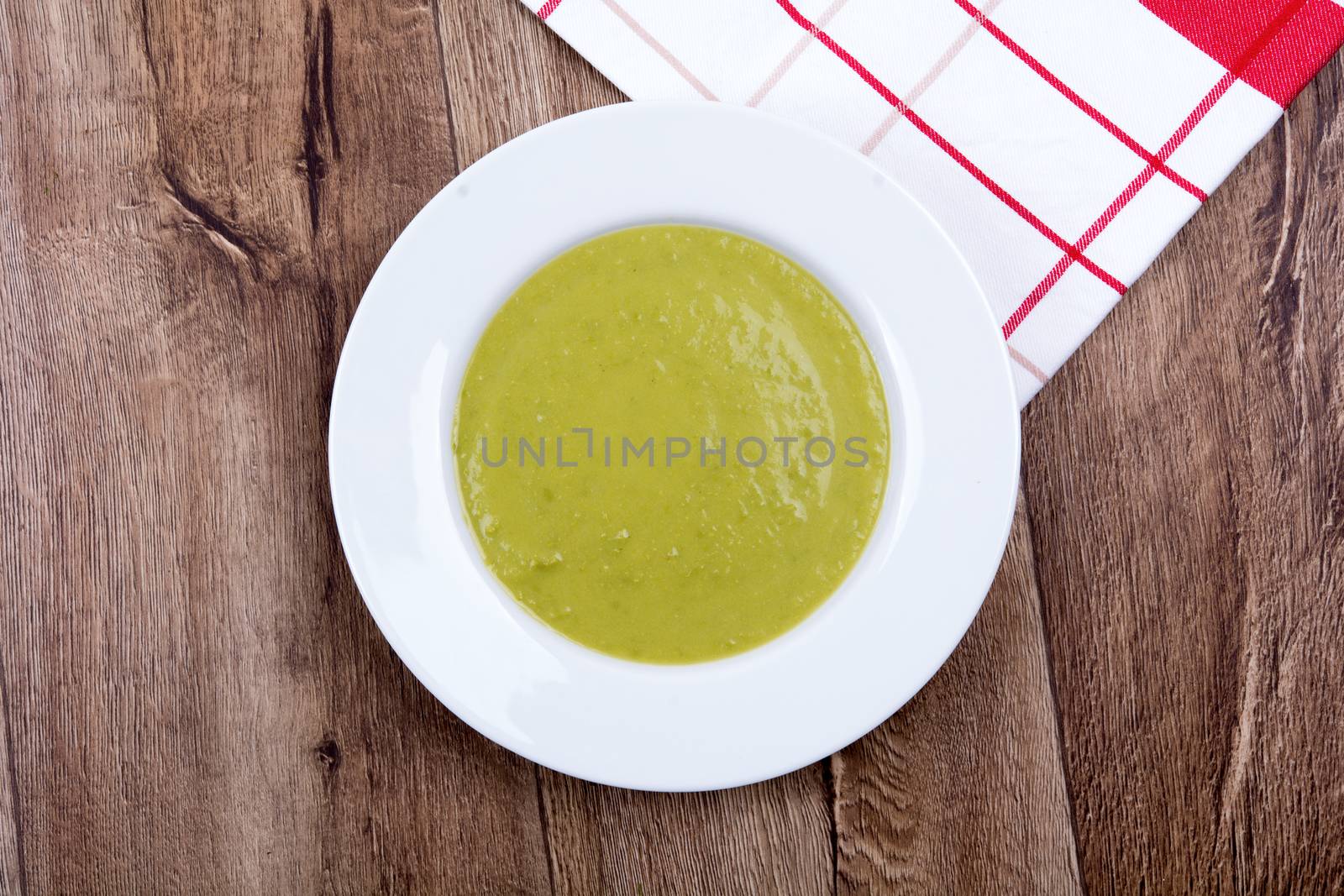 Vegetable split pea soup on a brown wooden background