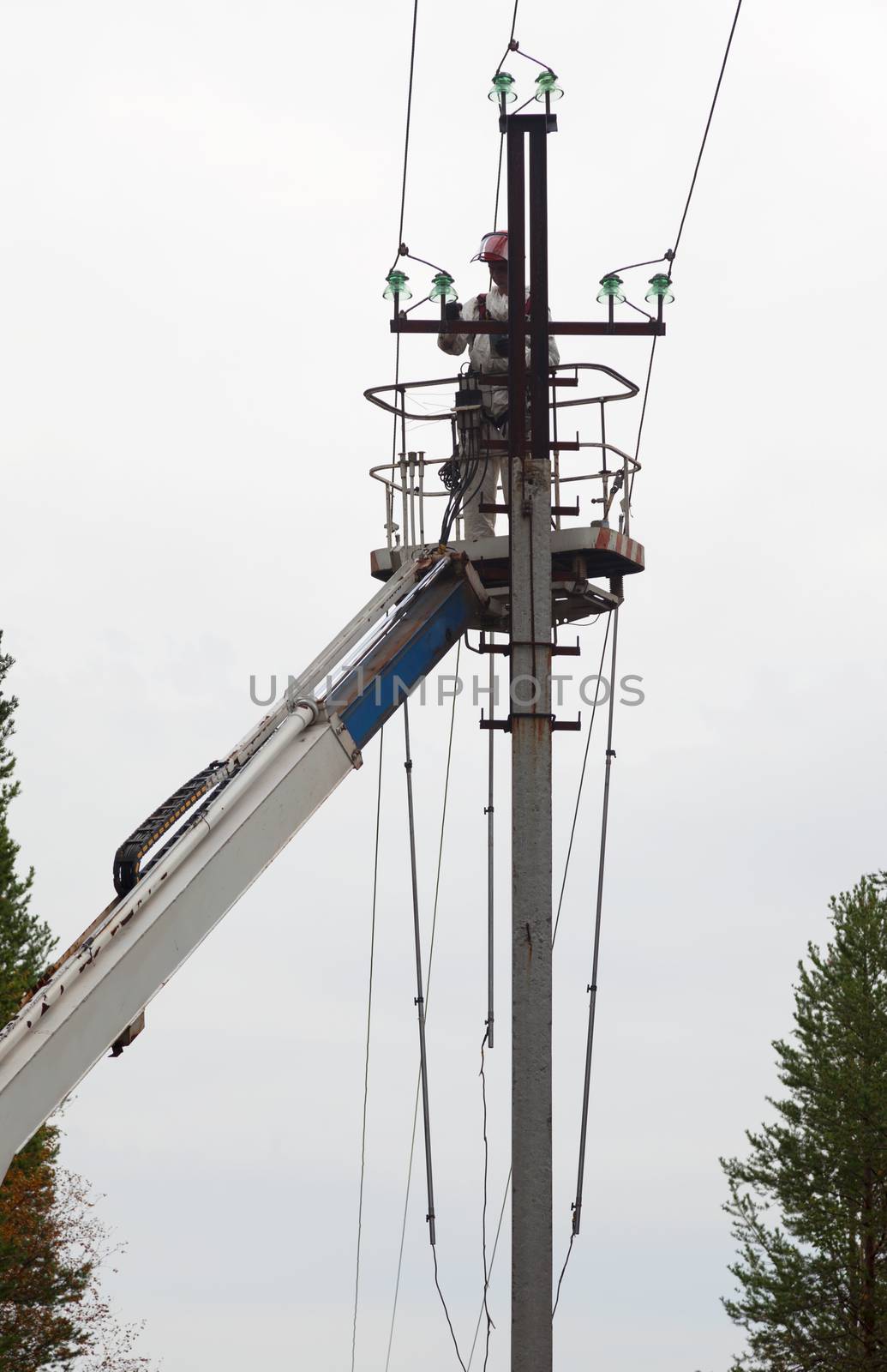 Electric is working on a pole in a special lift vehicles