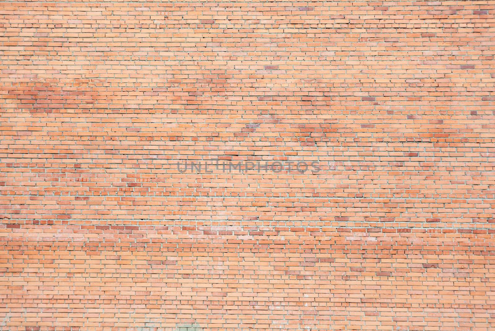 Large uneven wall of red different shades bricks