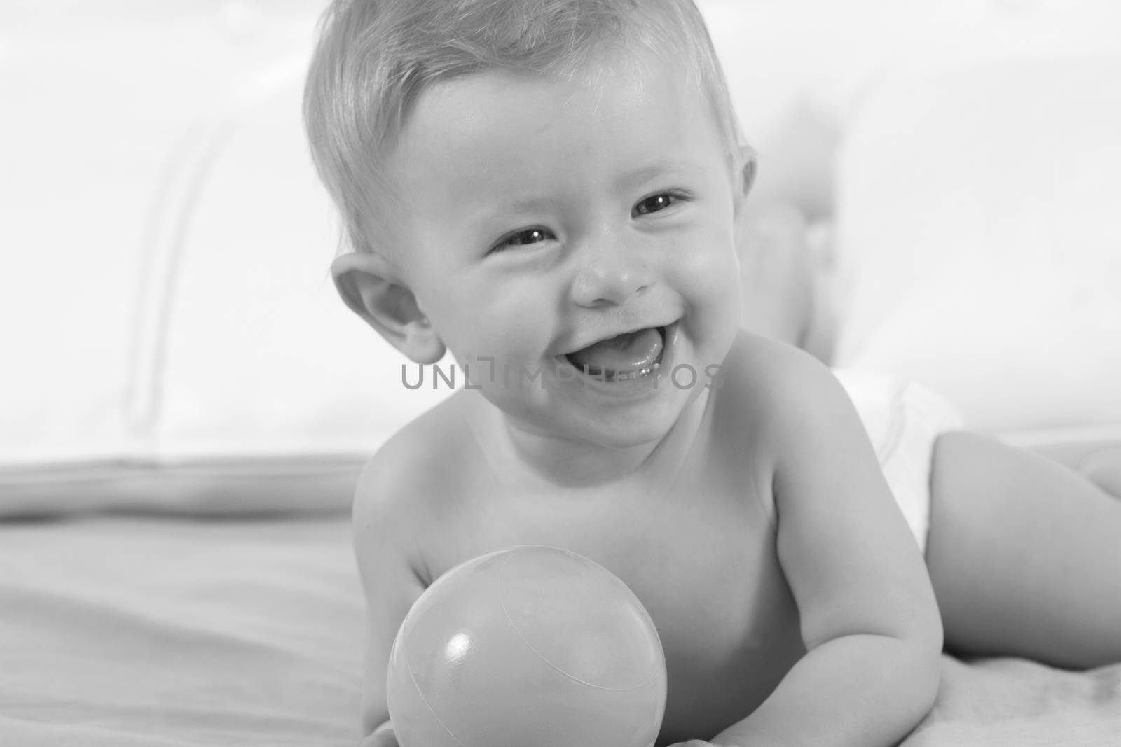 Beautiful and cheerful little girl playing with ball