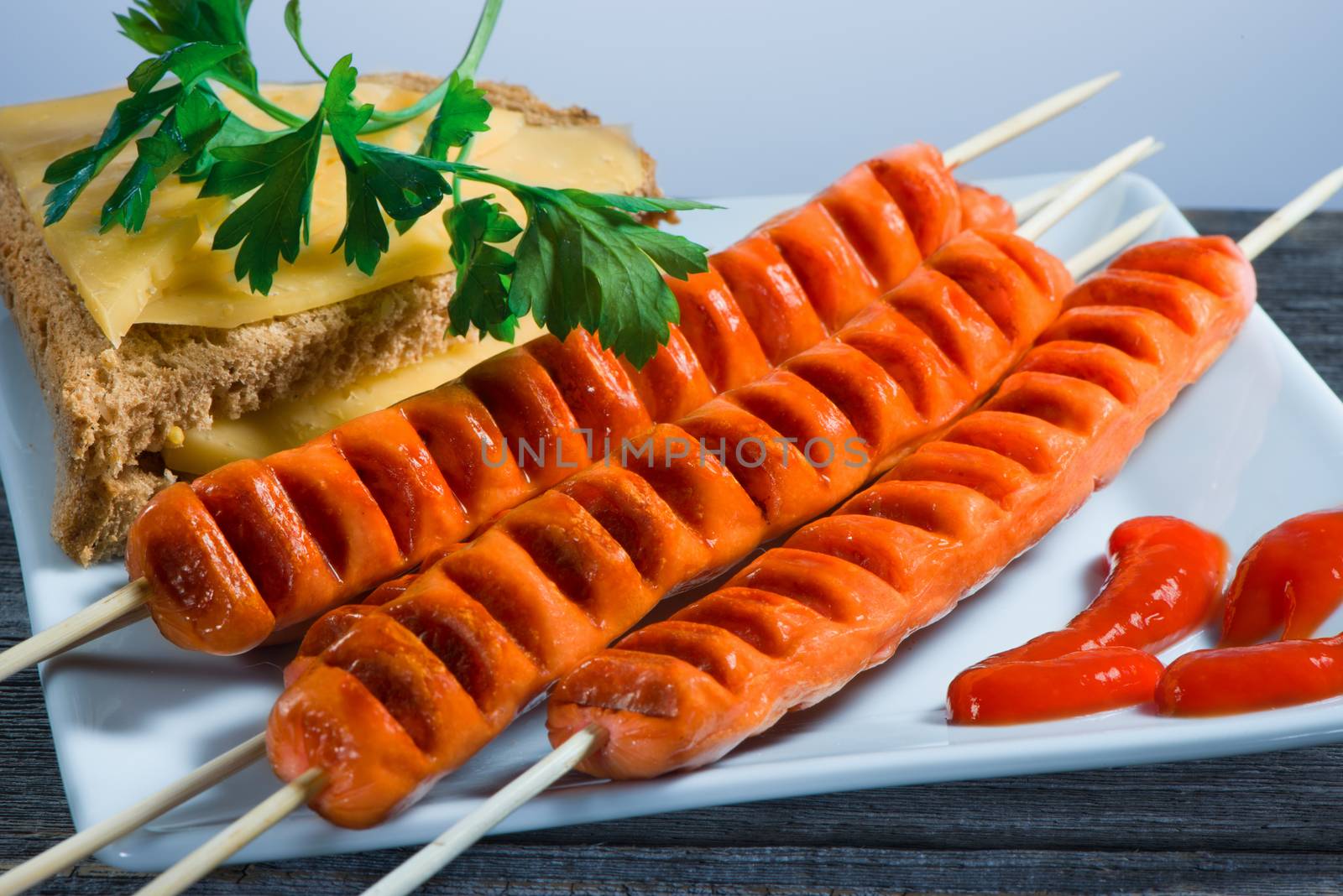 The sausages made on a grill and greens plate by fotooxotnik