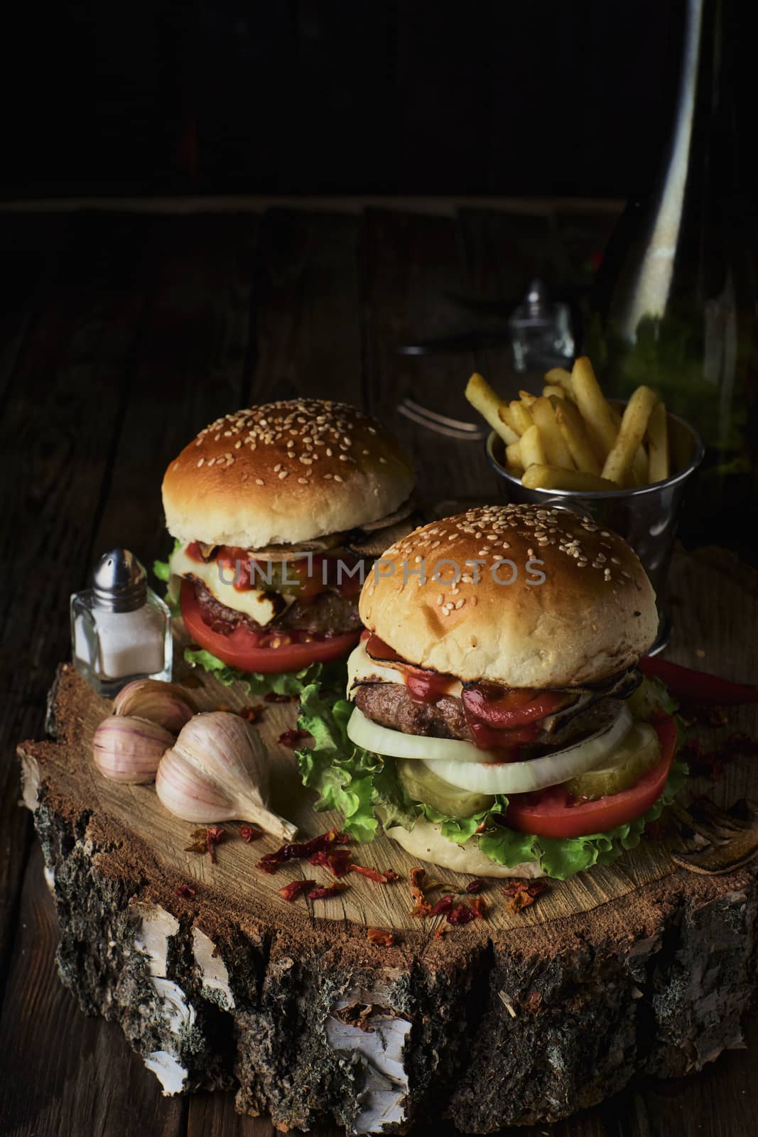 Delicious burgers in a rustic style on dark wooden background.