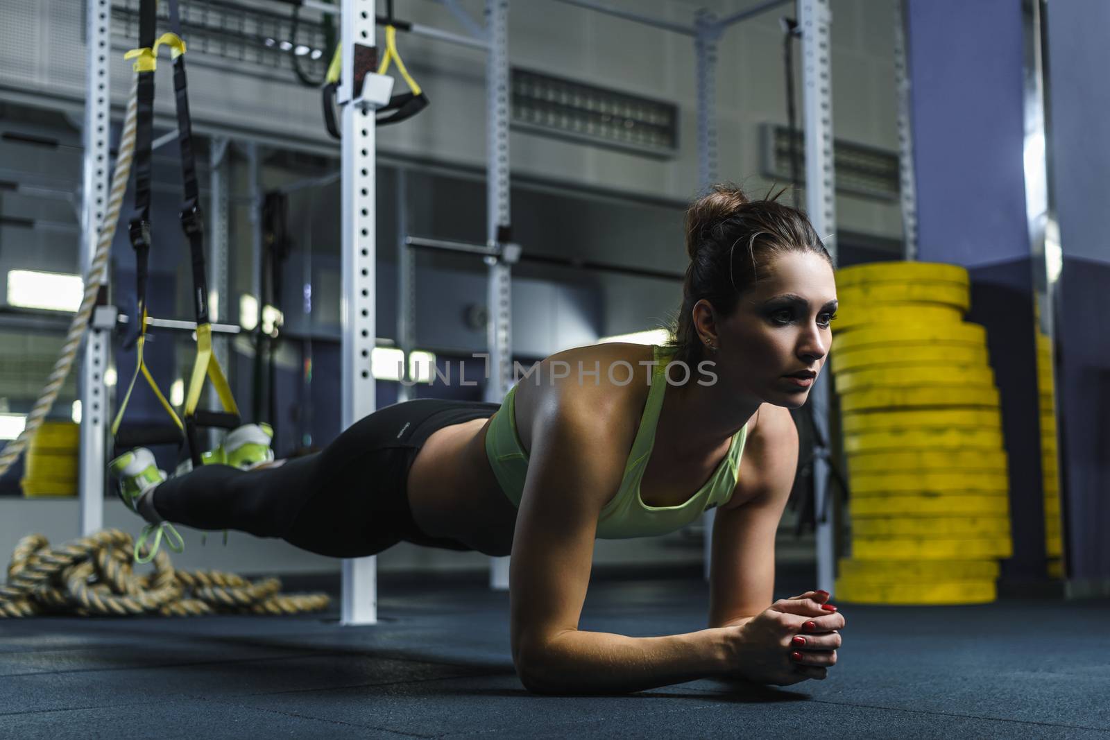 attractive muscular woman CrossFit trainer stand in plank during workout by mrakor