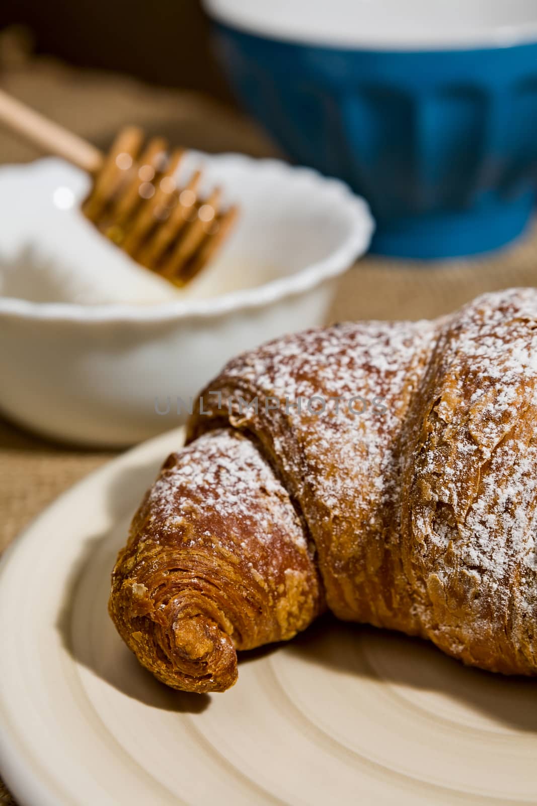 Closeup of a croissant on a plate by LuigiMorbidelli