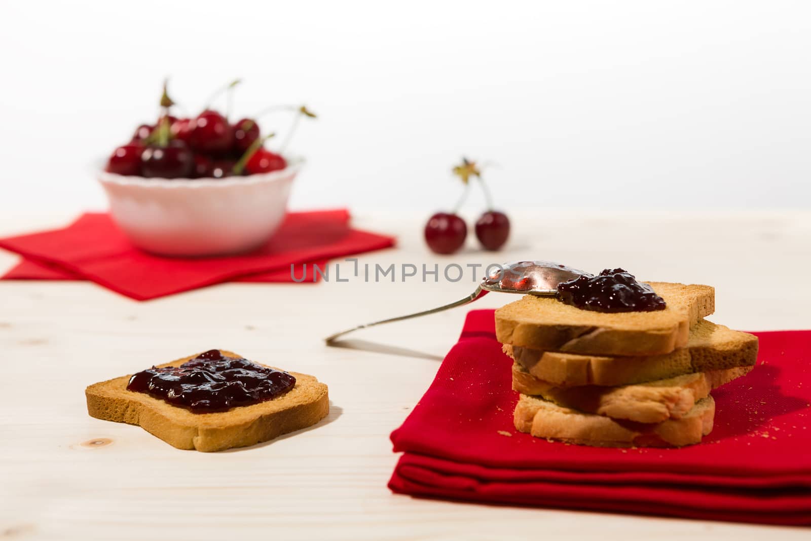 Rusk with cherry jam and cherry fruit on background