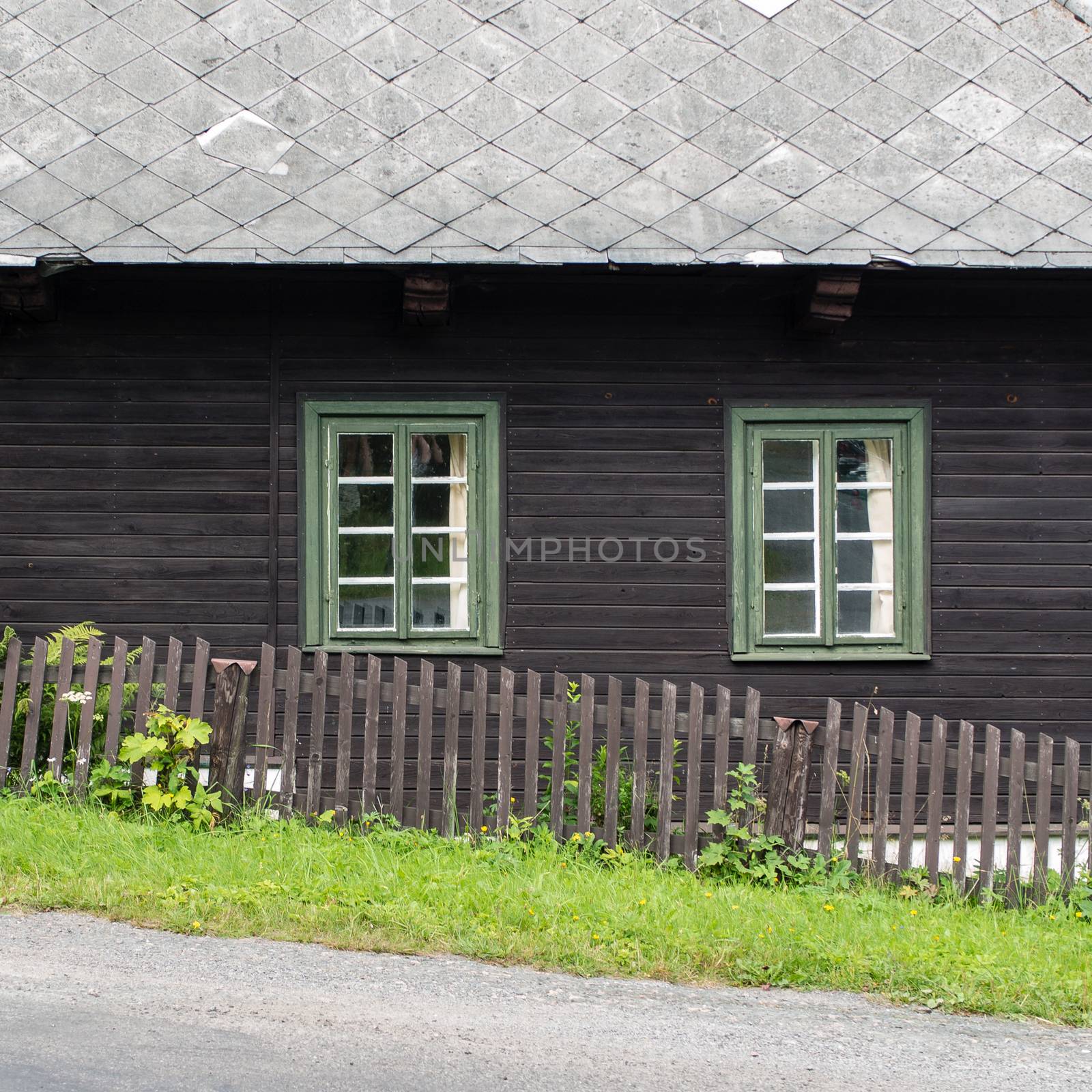 Authentic rustic nd brown mountain cottage front with windows and stones in Orlicke Mountains, Czech republic, Europe