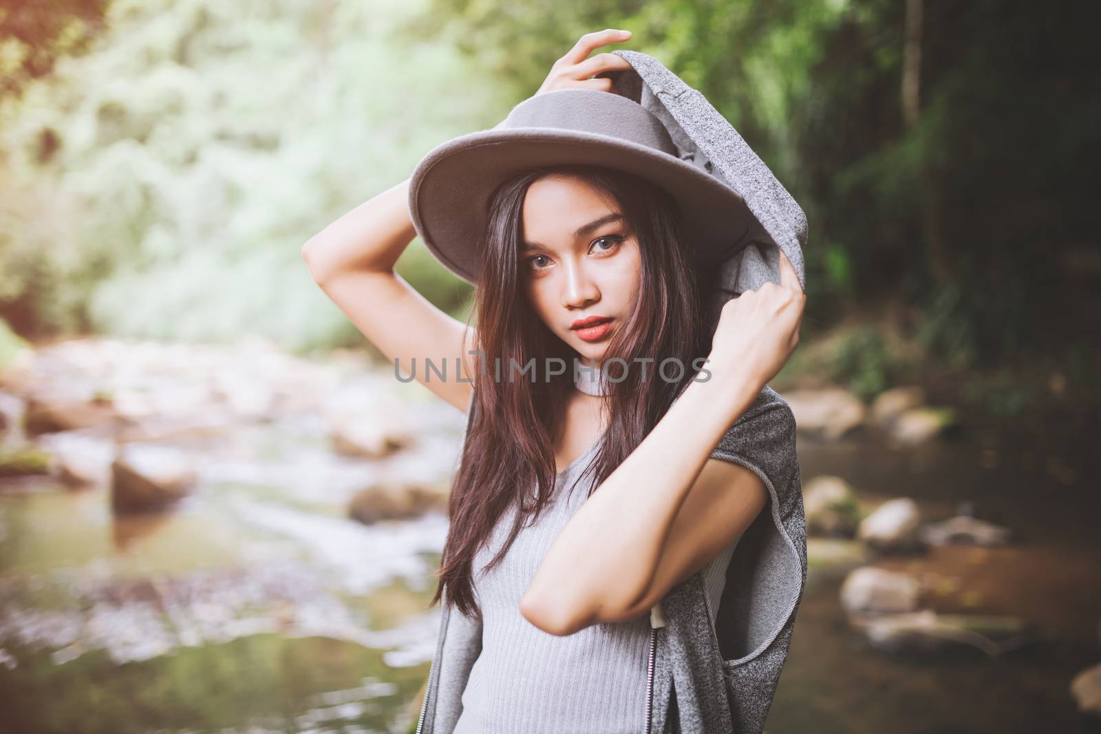 Beautiful asian woman smiling around the nature green and water.