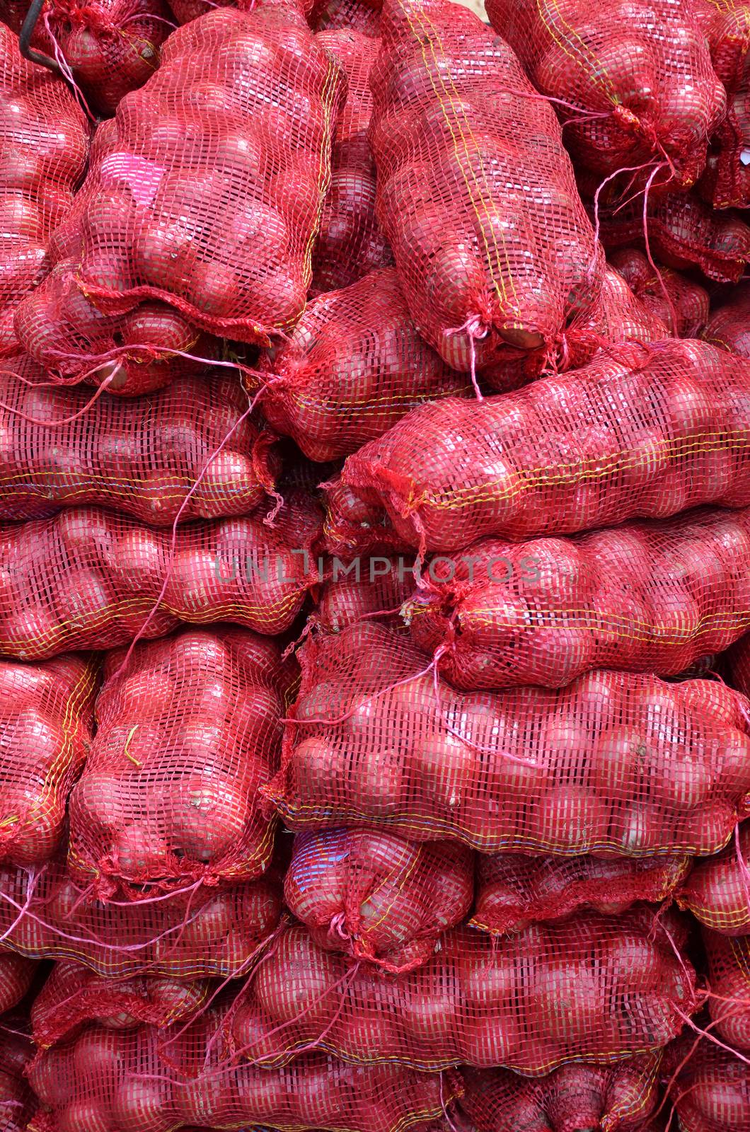 Sacs containing Large onion stacked for sale by tang90246