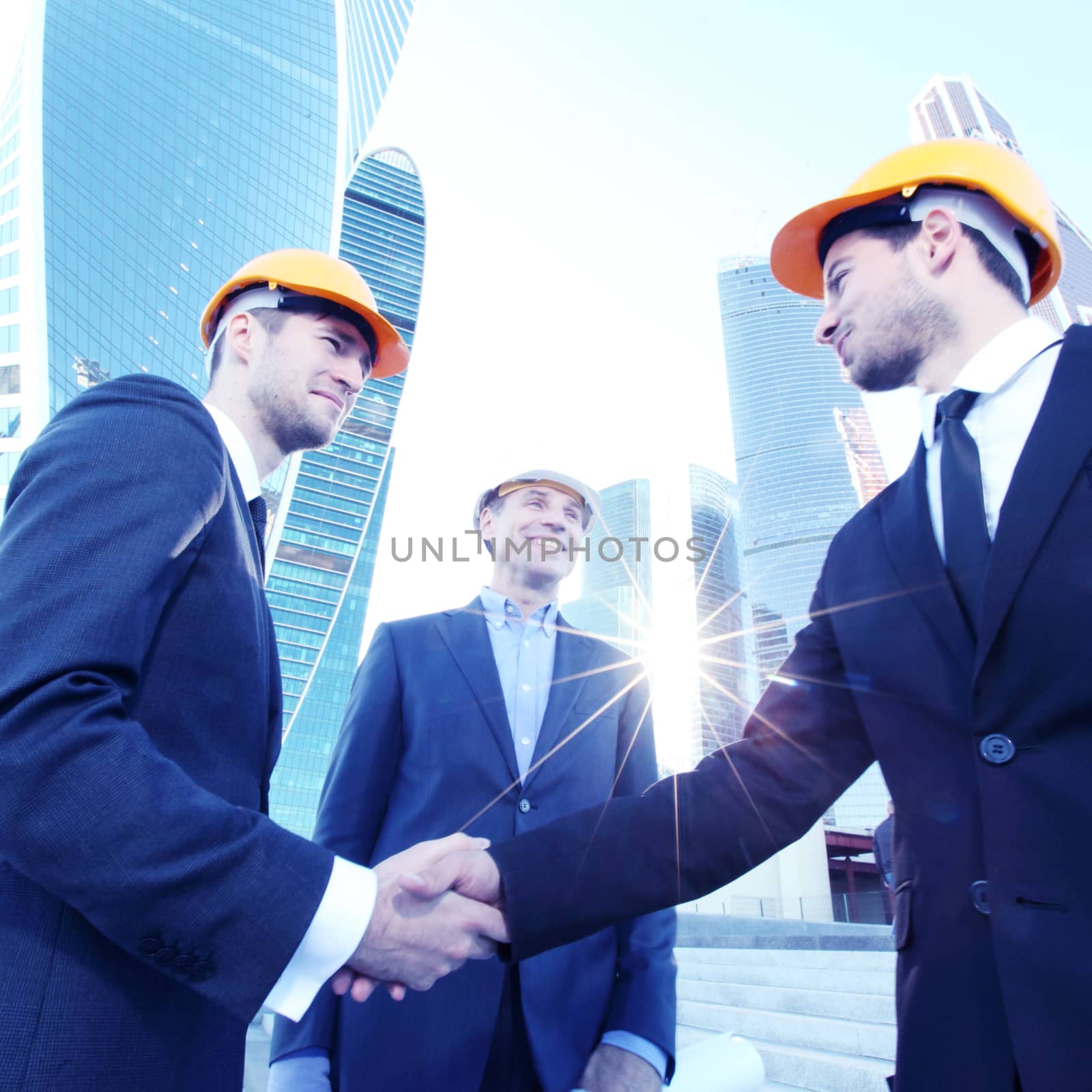 Investor and contractor shaking hands, view from below