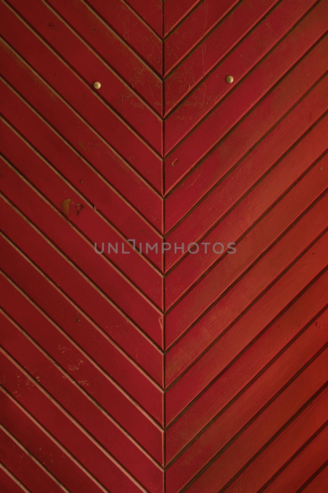 Red vintage grunge stained aged painted wooden panel medieval style door with diagonal planks