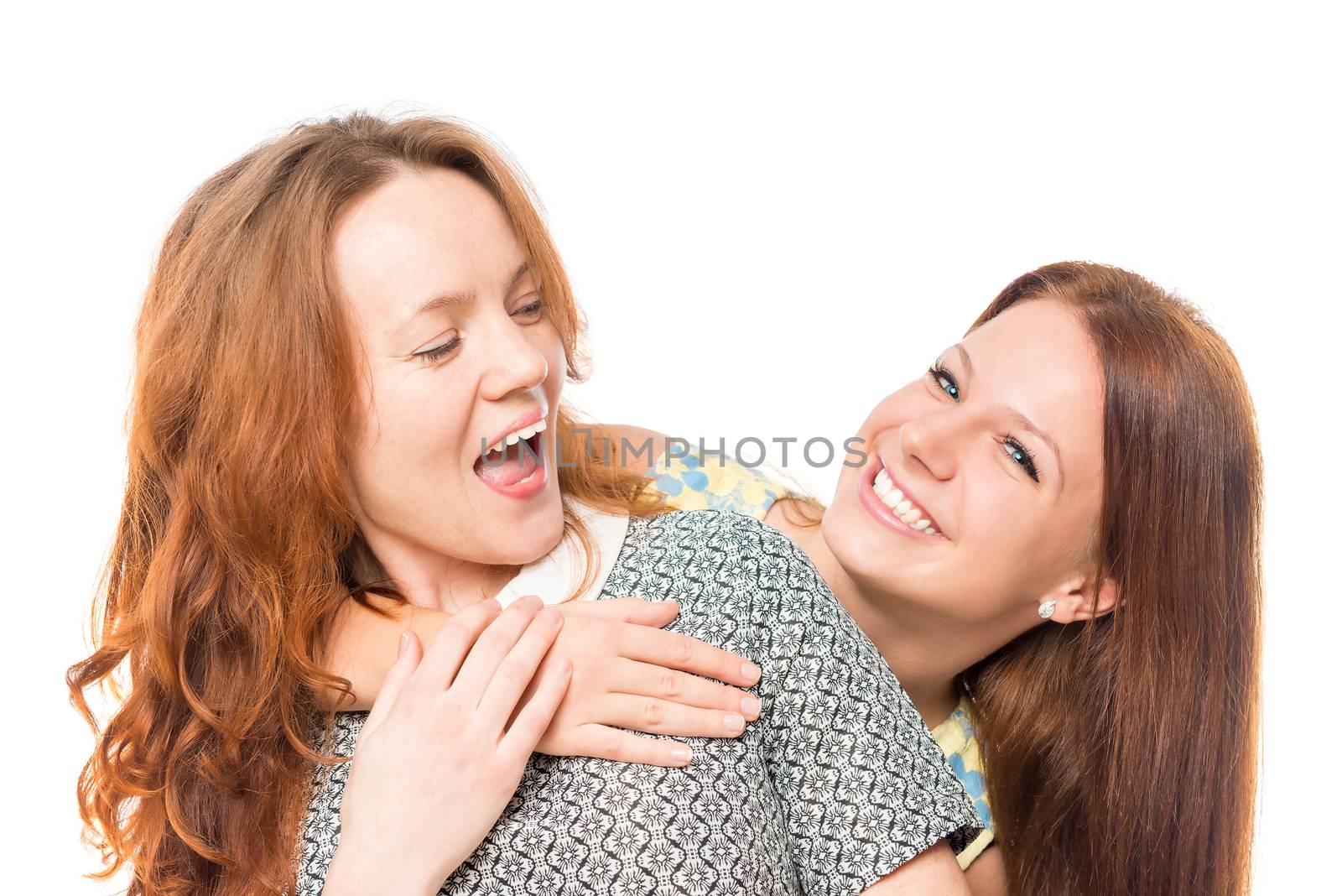 Two cheerful girlfriends embrace on a white background