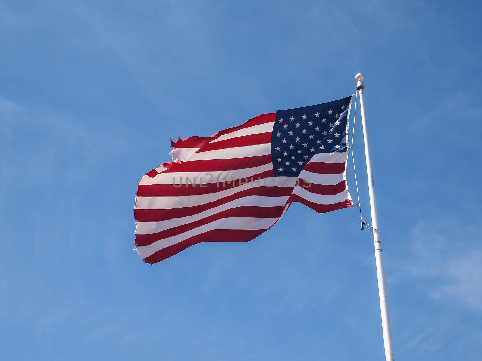 Tattered American Flag in the blue sky