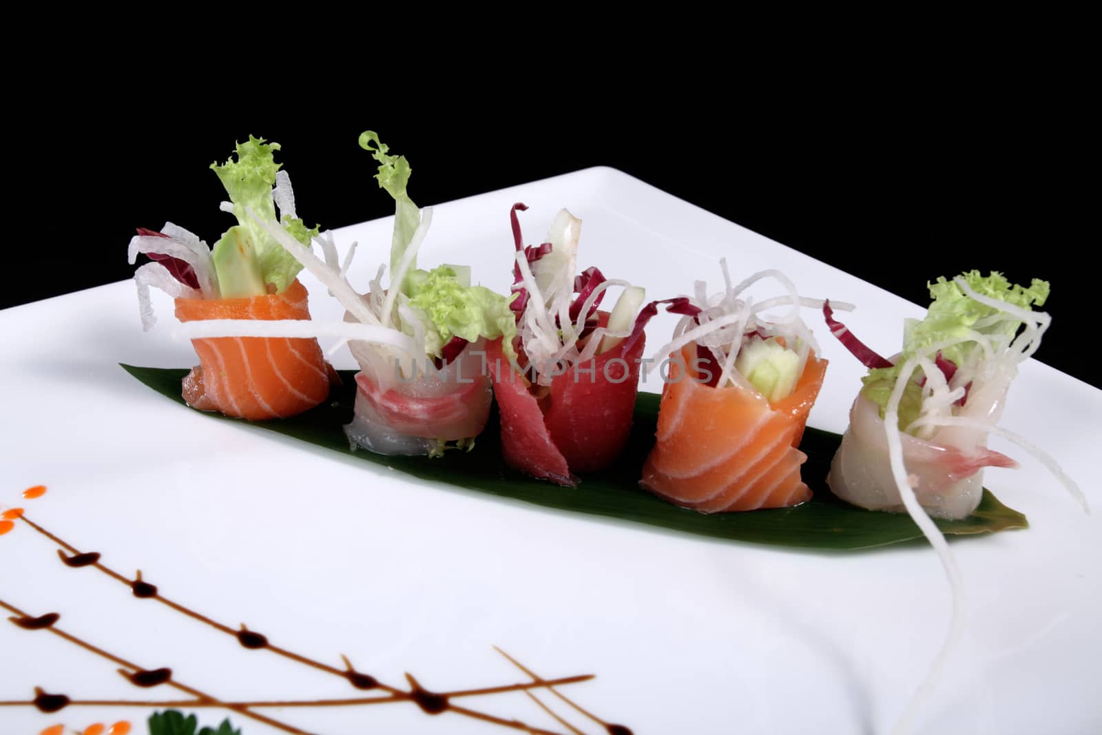 mixed sushi on white plate, black background