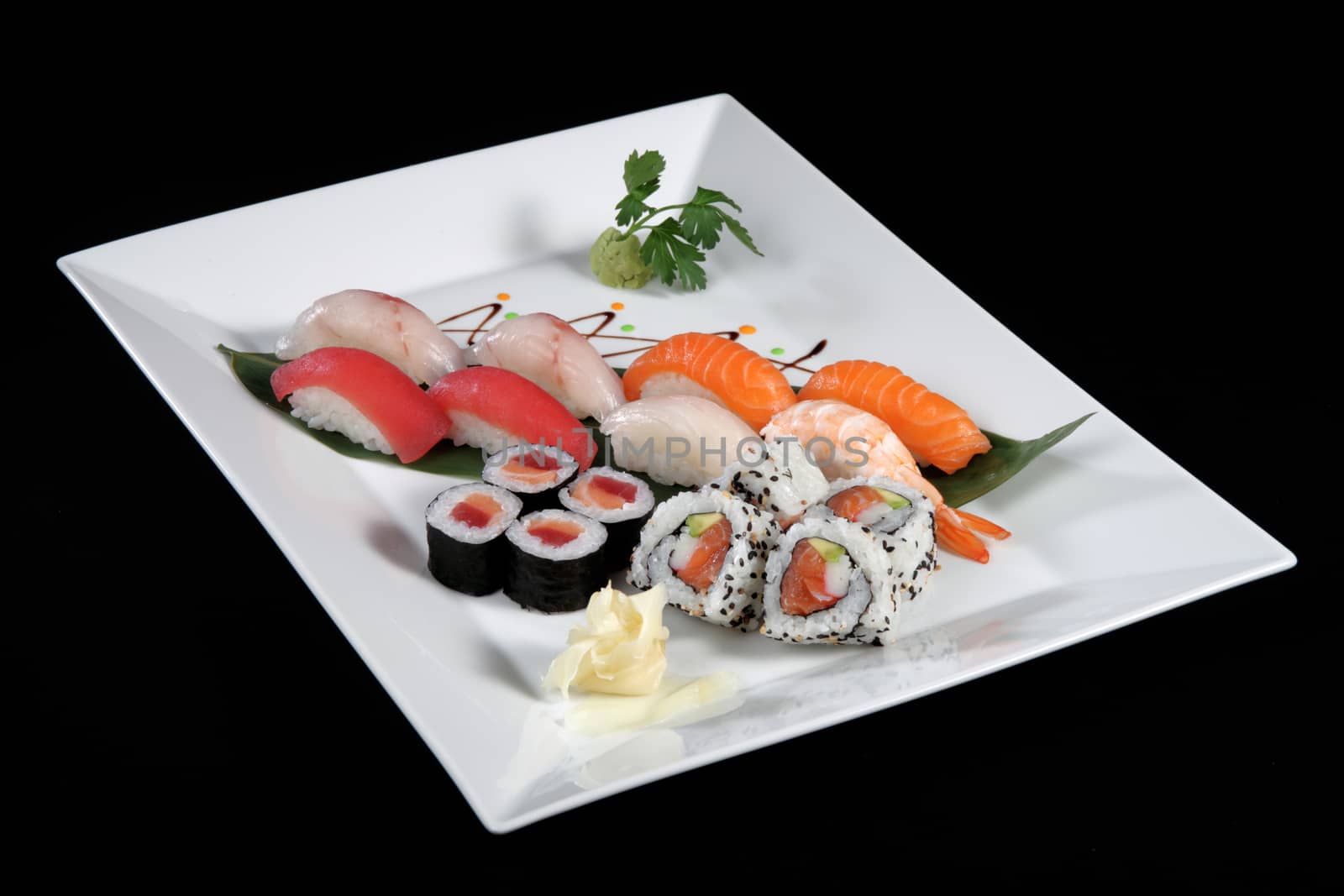 various sushi and sashimi with wasabi on white plate, black background