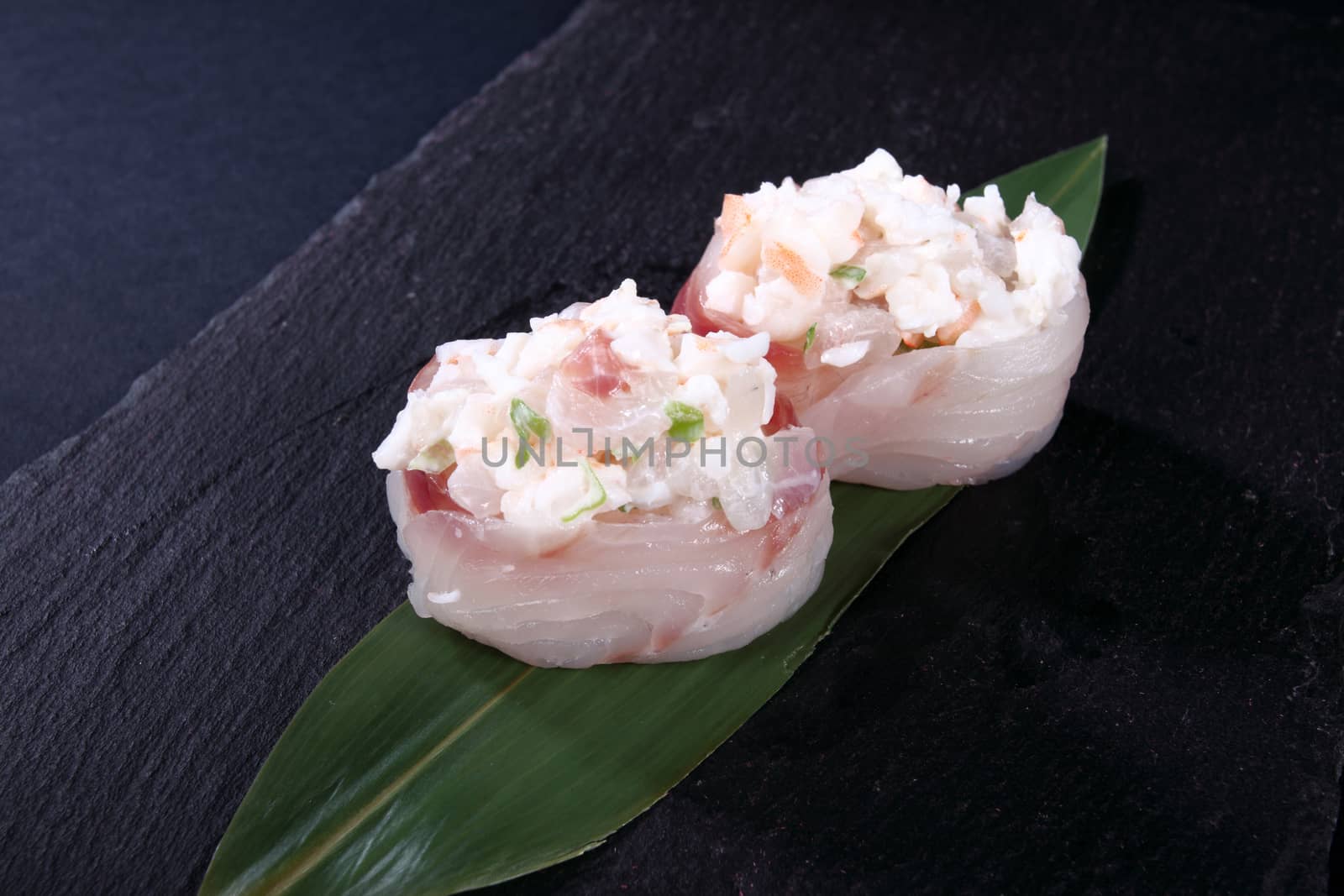 stew of sea bass on leaf green, black background