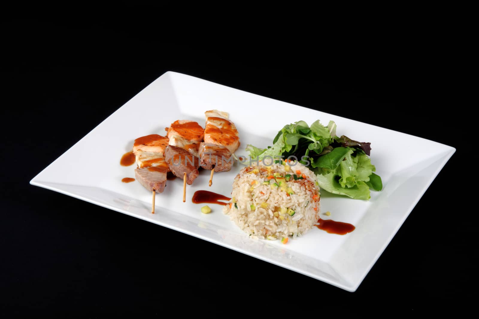 menu of kebabs with rice and vegetables in white dish, on black background
