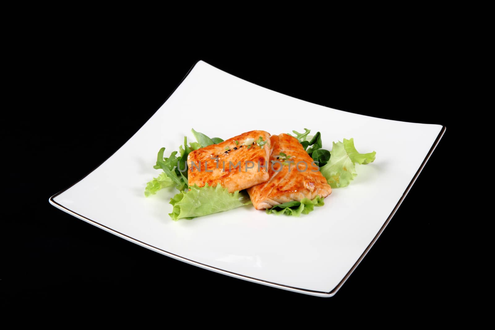 grilled salmon with vegetables on square plate, black background
