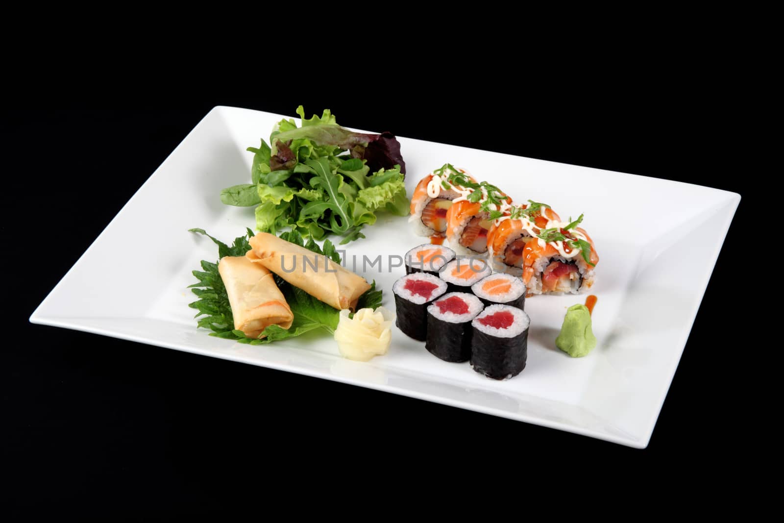 menu of sushi and roll fish with vegetables and wasabi on white plate, on black