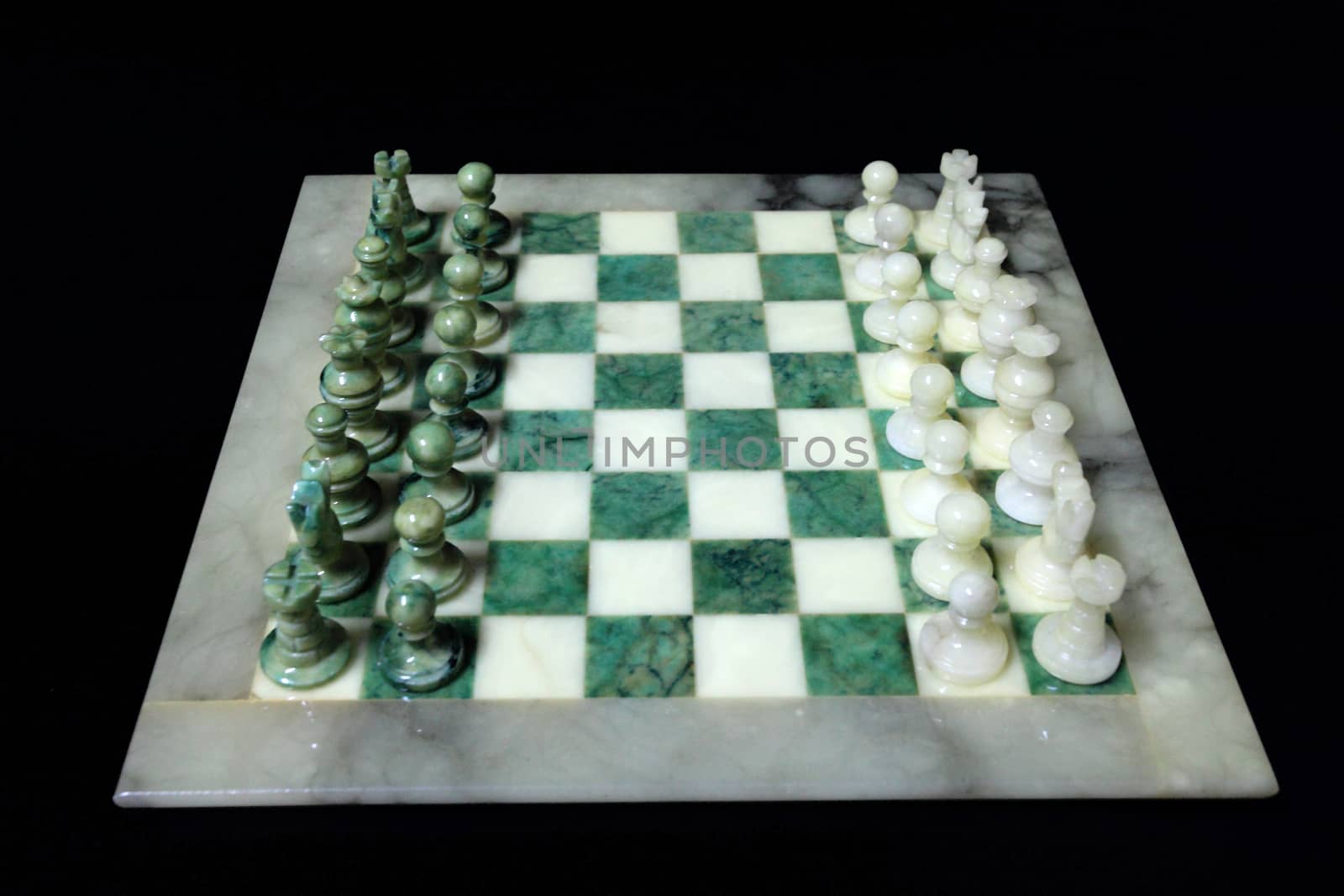 chessboard and alabaster chess on a black background