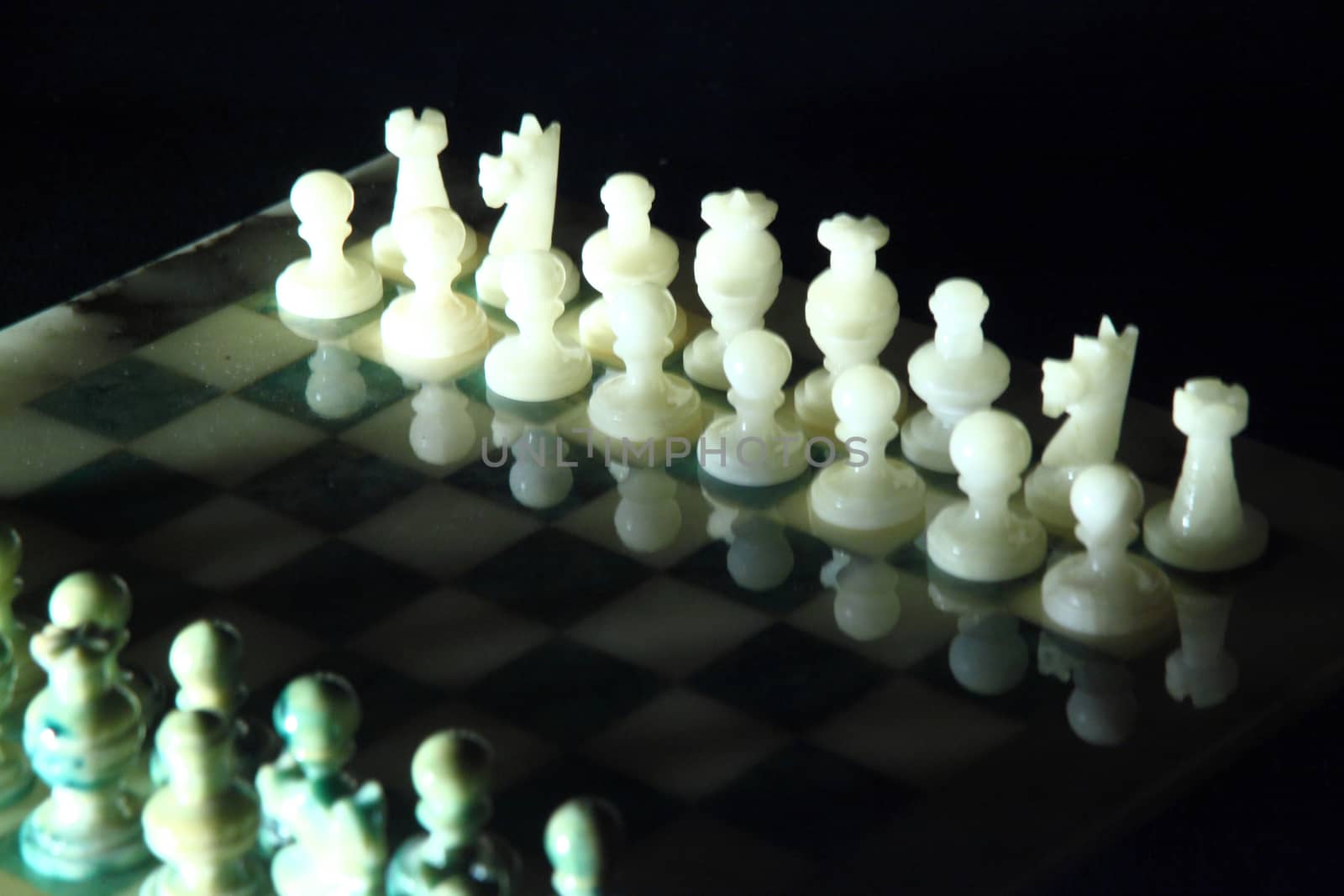 chessboard and alabaster chess on a black background