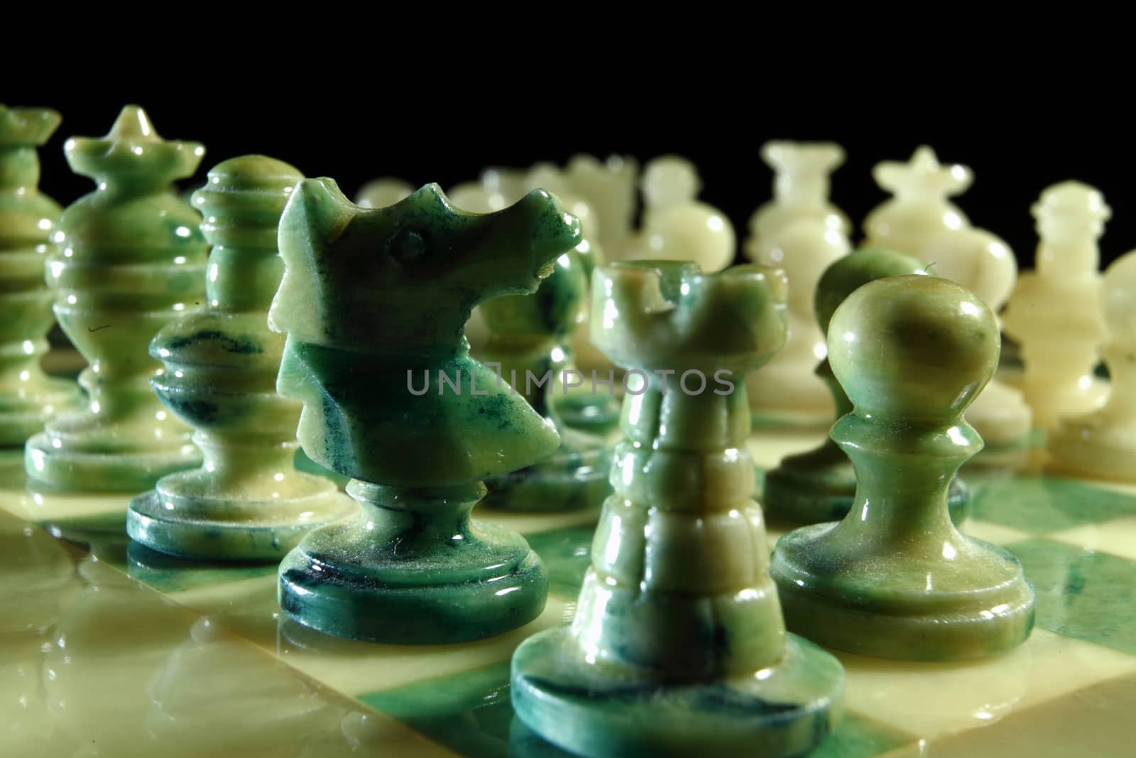 chessboard and alabaster chess on a black background