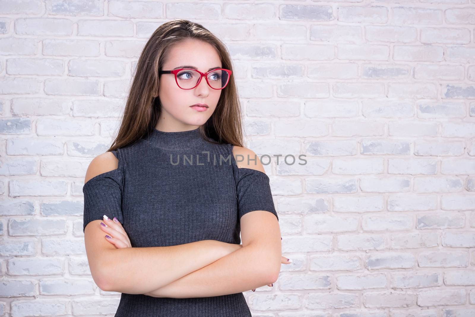 Young beautiful girl model with long hair and red glasses in office look