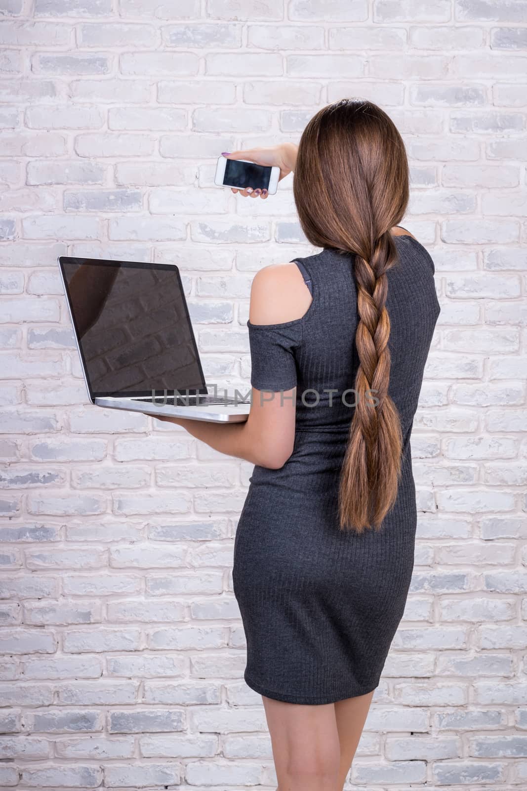 Young beautiful girl model with long hair imitates business lady, office manager or administrator with notebook and telephone