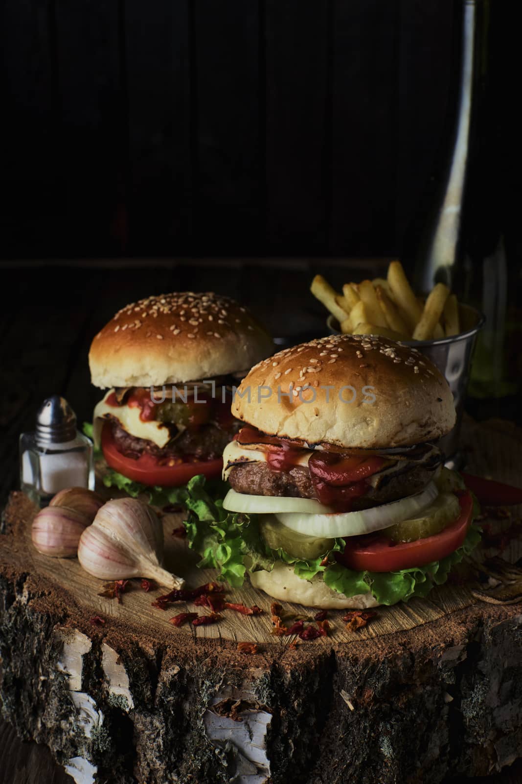 Delicious burgers in a rustic style on dark wooden background.