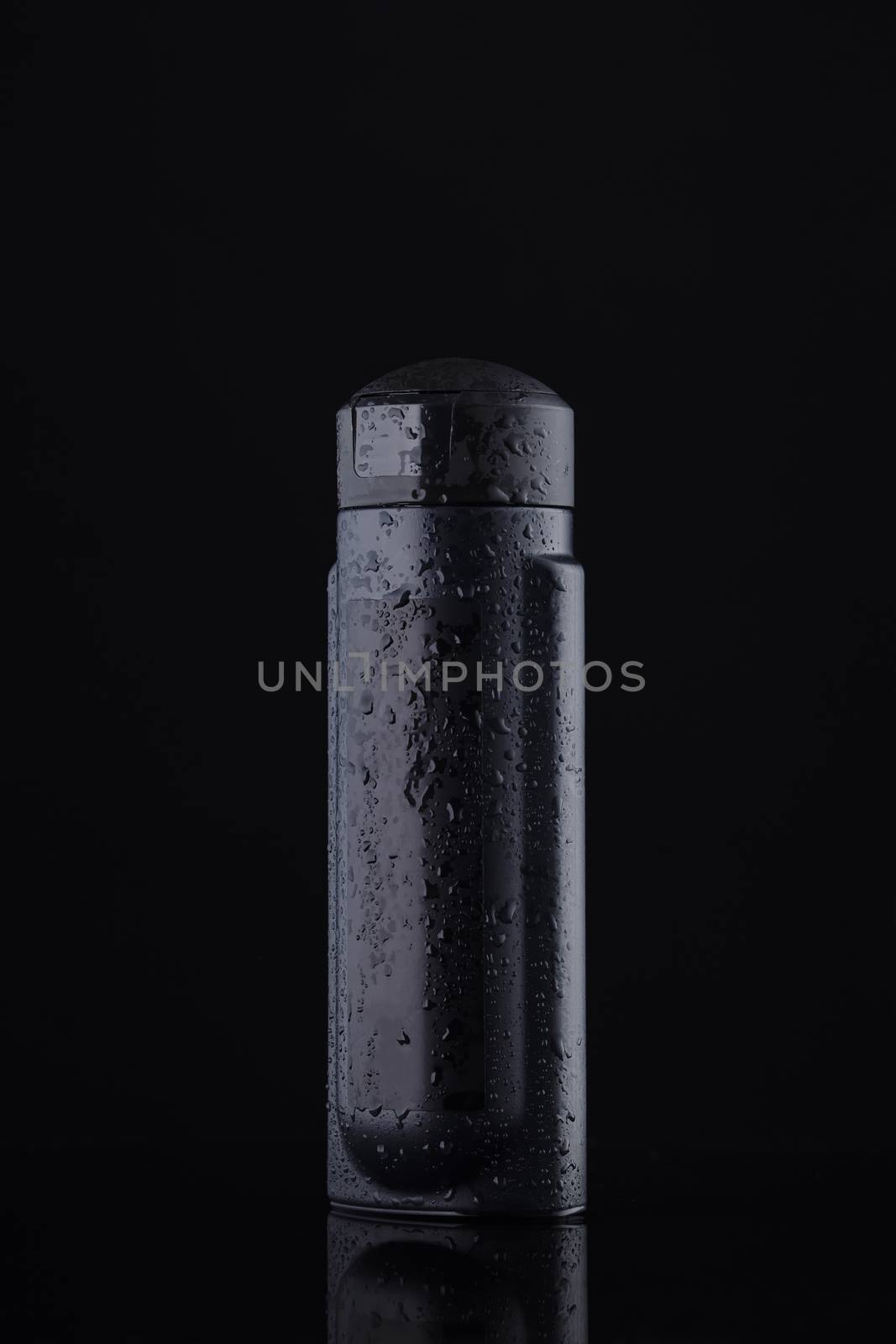 Black capacity for liquids and shampoo on a black background. The black color is a symbol of purity and order in a simple style.