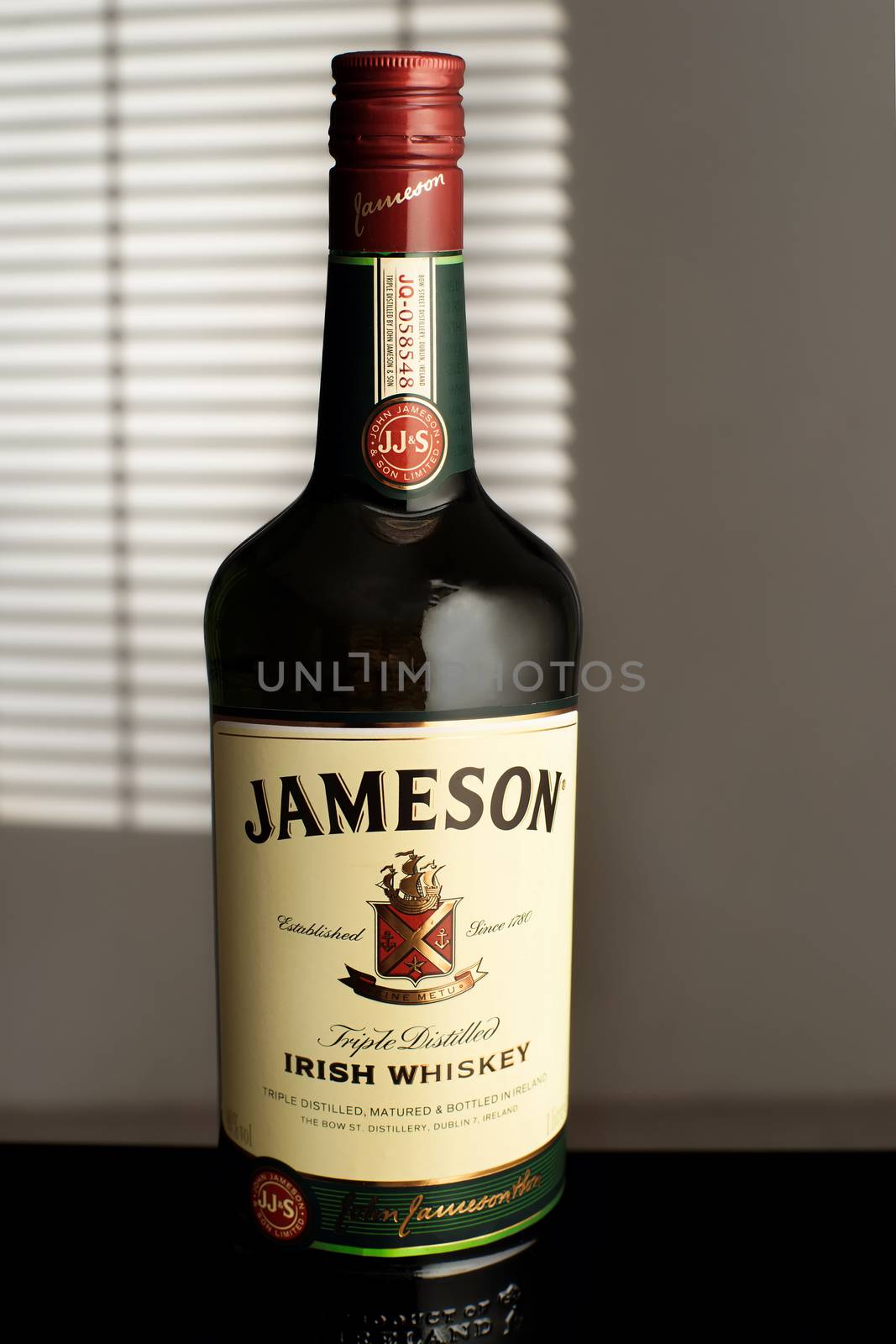 Jameson is a blended Irish whiskey produced by the Irish Distillers subsidiary of Pernod Ricard. A bottle Jameson in the room, illuminated by the light from the window