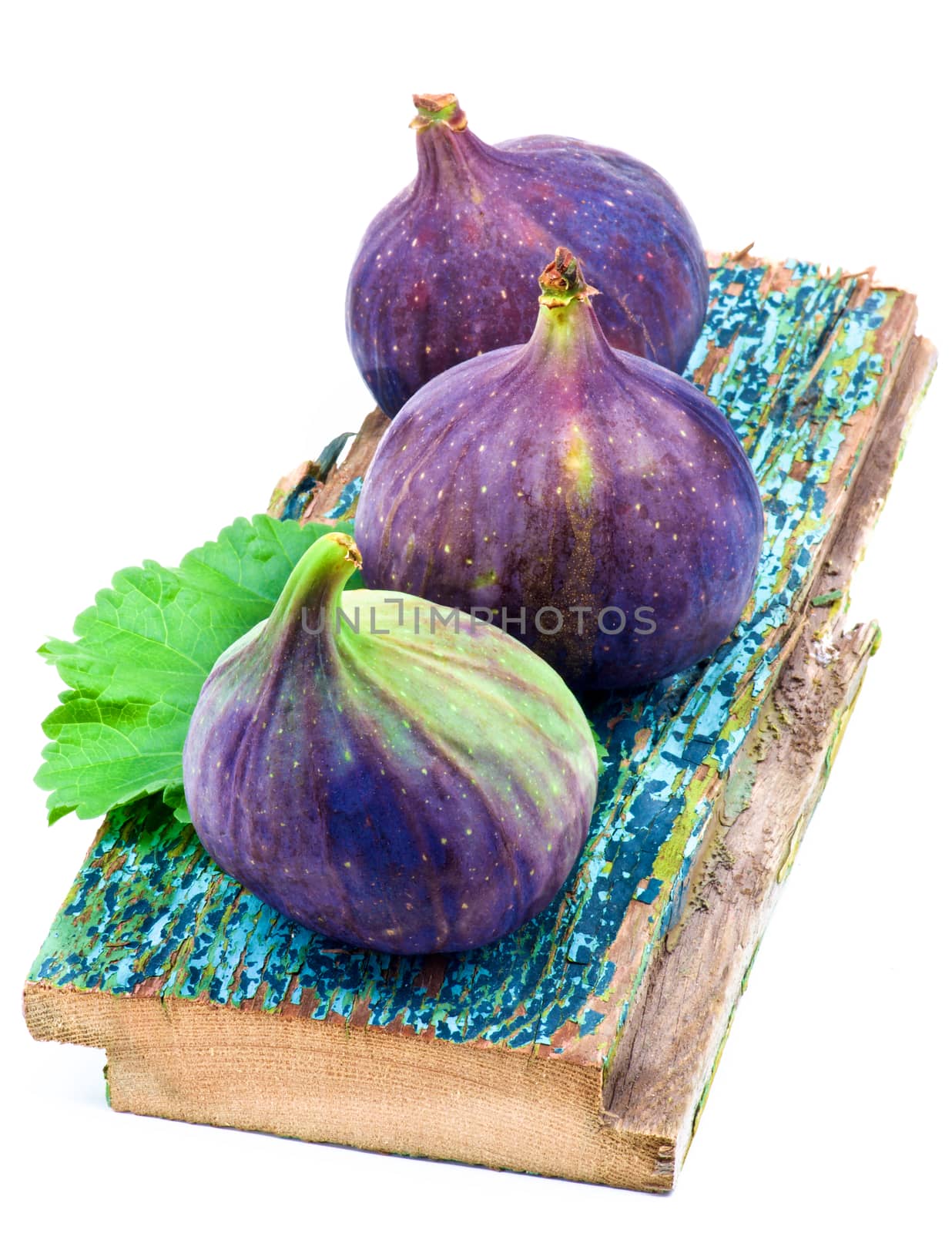 Three Perfect Ripe Fig on Cracked Wooden Planch isolated on White background